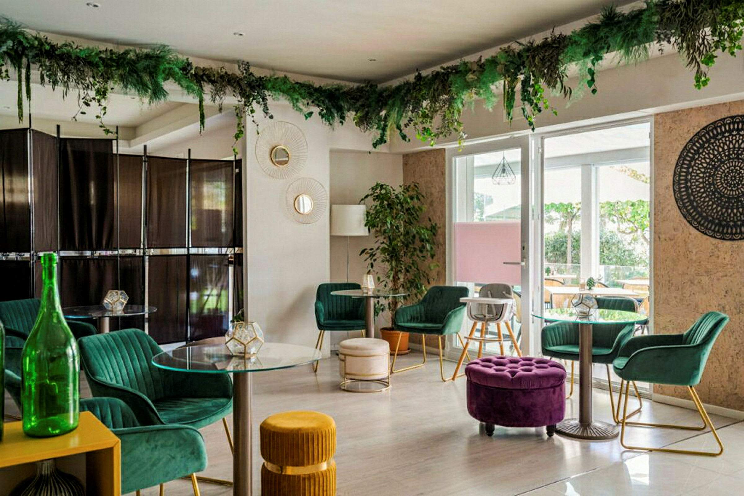 Et stilfuldt indrettet rum med elegante møbler, glasborde og grøn planteudsmykning hængende fra loftet. (AI-genereret tekst)