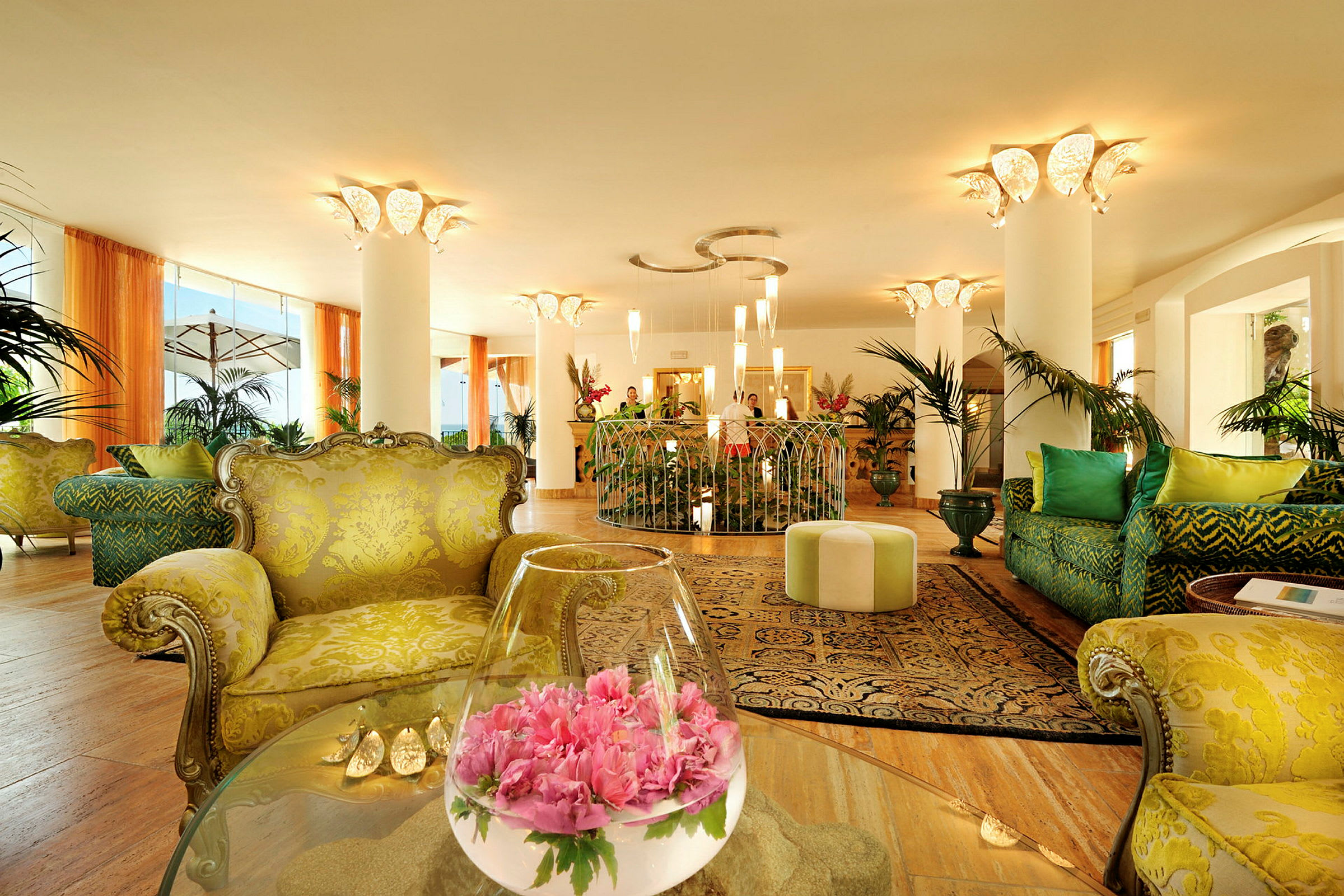 En elegant hotellobby med farverige og komfortable siddepladser, borde med dekorationer og grønne planter. (AI-genereret tekst)