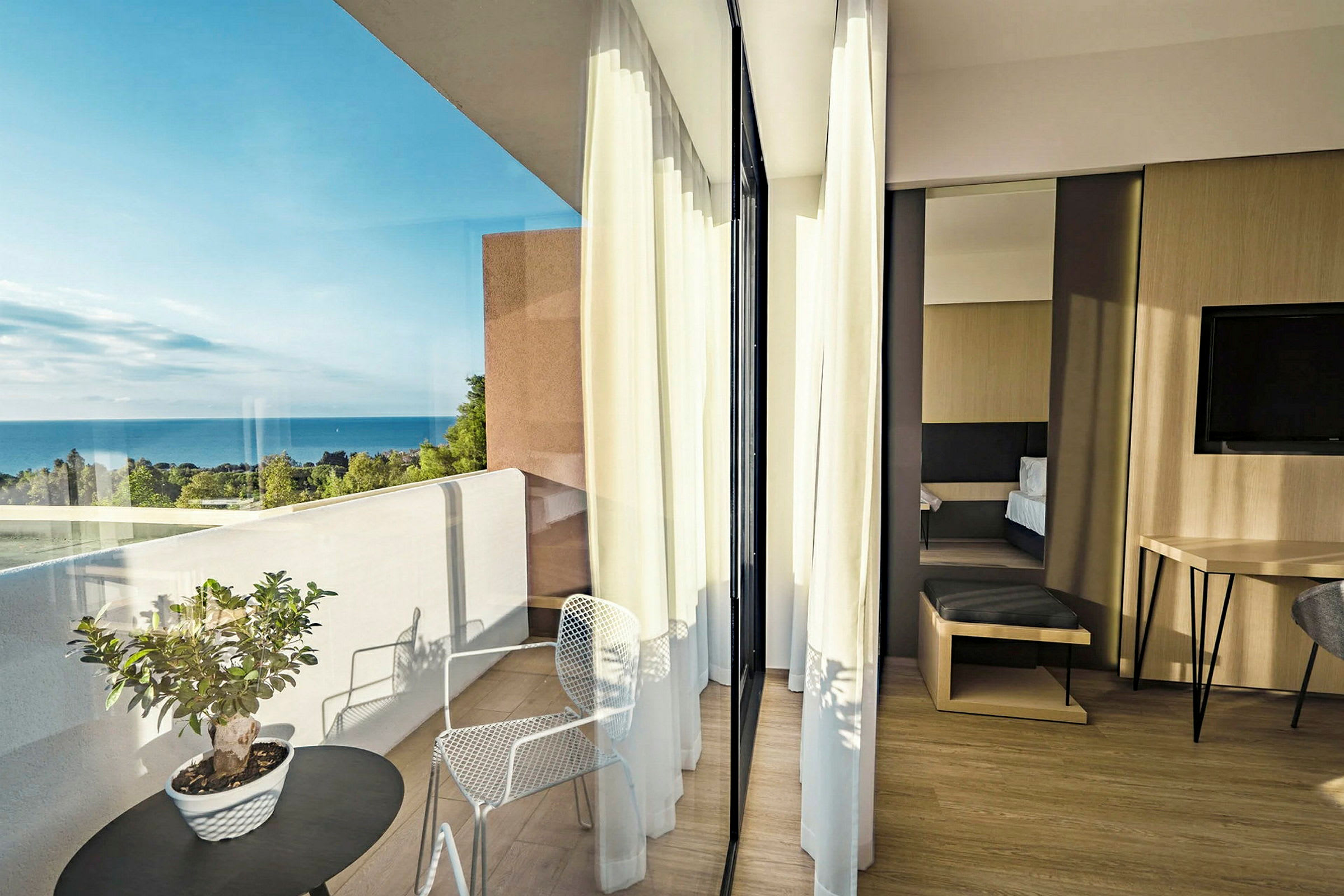 Et moderne indrettet hotelværelse med balkon og havudsigt. (AI-genereret tekst)