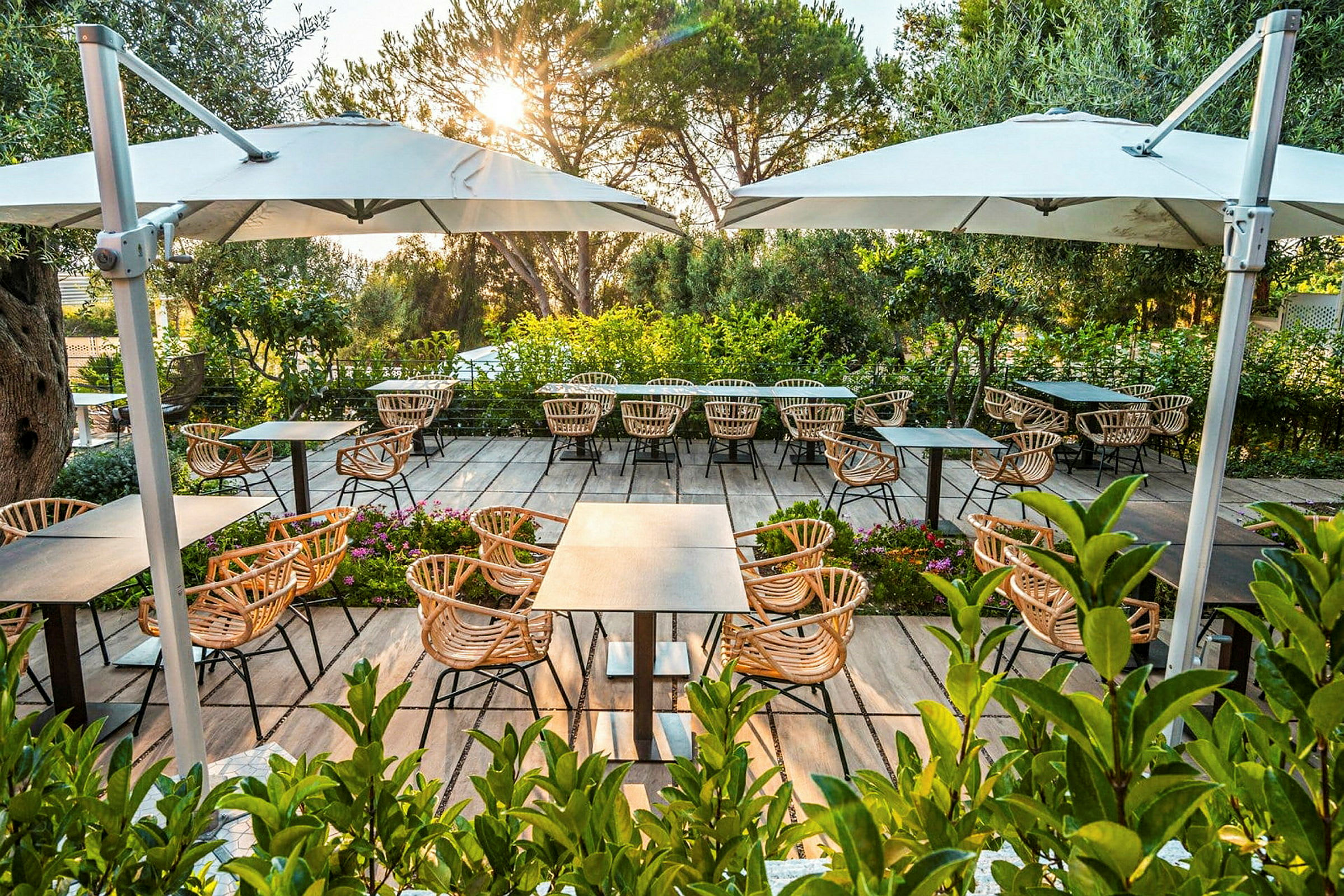 Udendørs servering med træborde og stole på en terrasse med parasoller. (AI-genereret tekst)