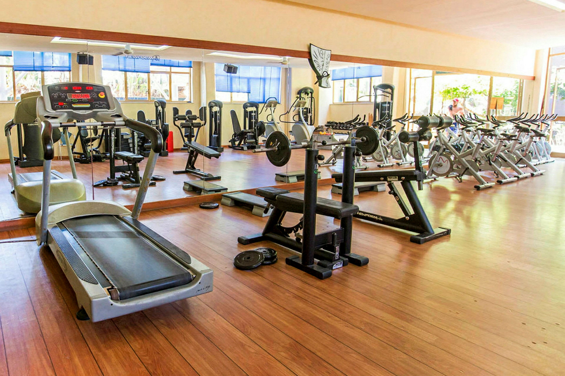 Interiørbillede af et fitnesscenter med forskellige træningsmaskiner og udstyr. (AI-genereret tekst)