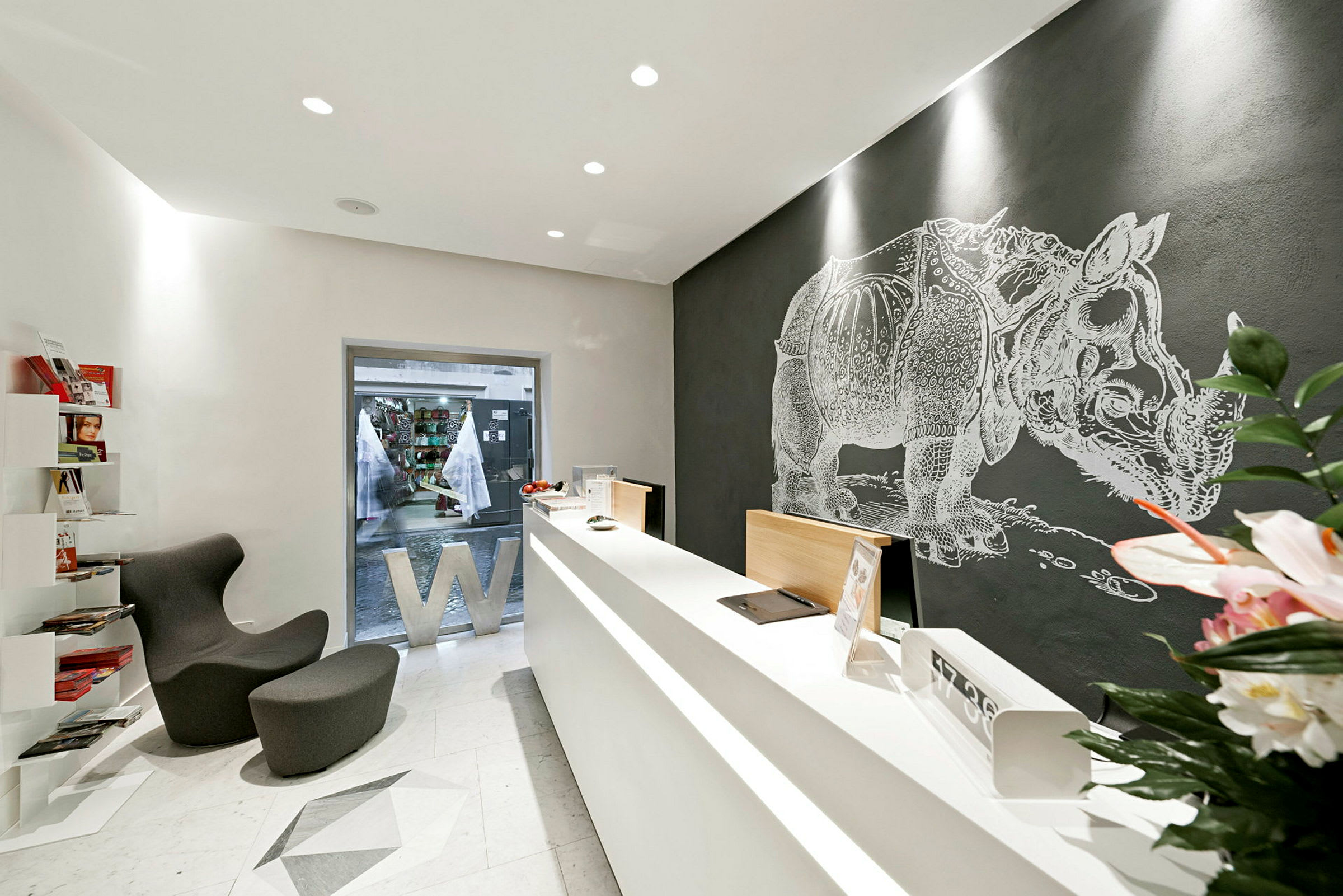 Et moderne kontor med minimalistisk design, reception og et vægmaleri af en næsehorn. (AI-genereret tekst)