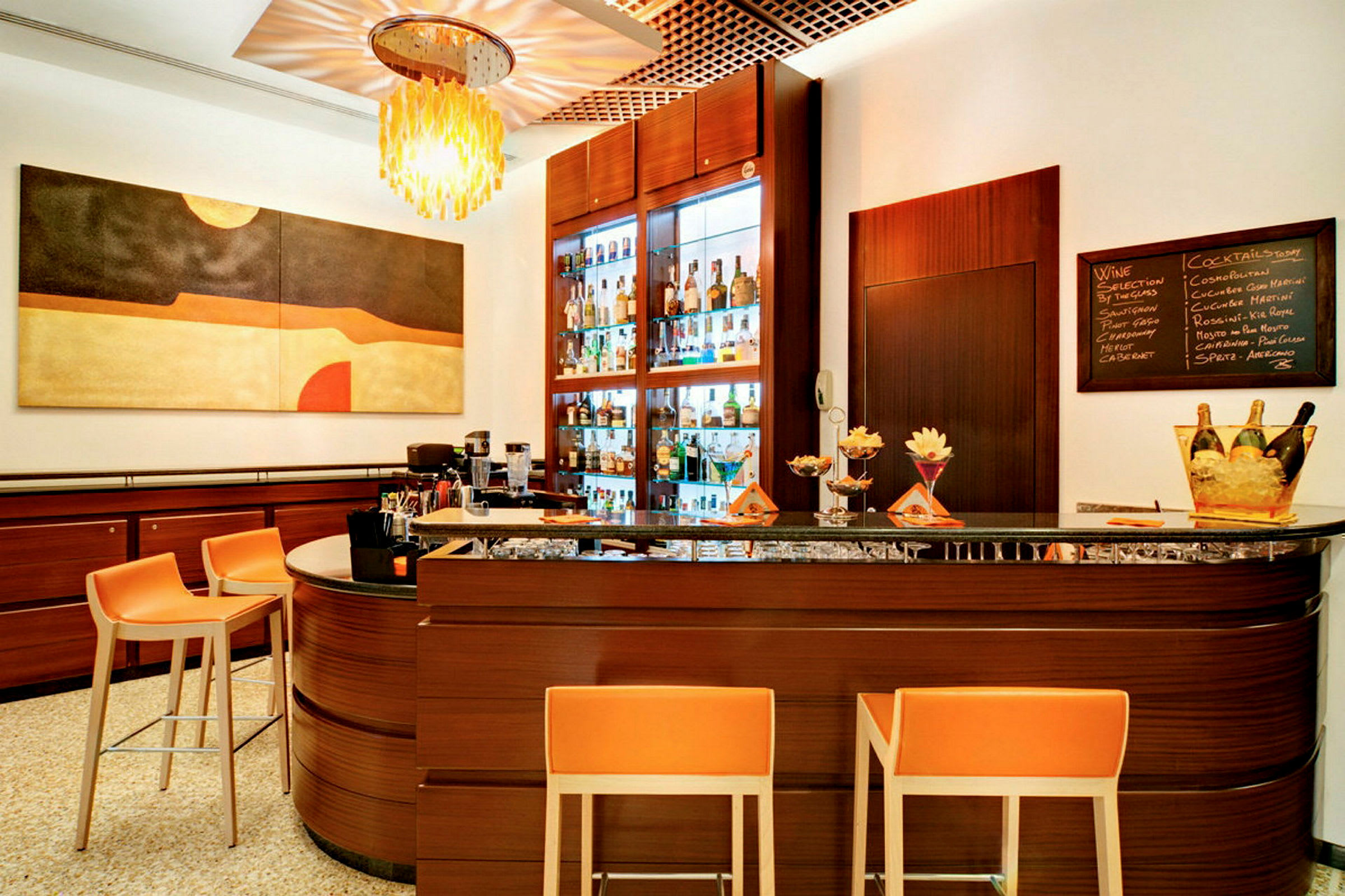 En moderne hotelbar med orange stole foran en mørkebrun bardisk. (AI-genereret tekst)