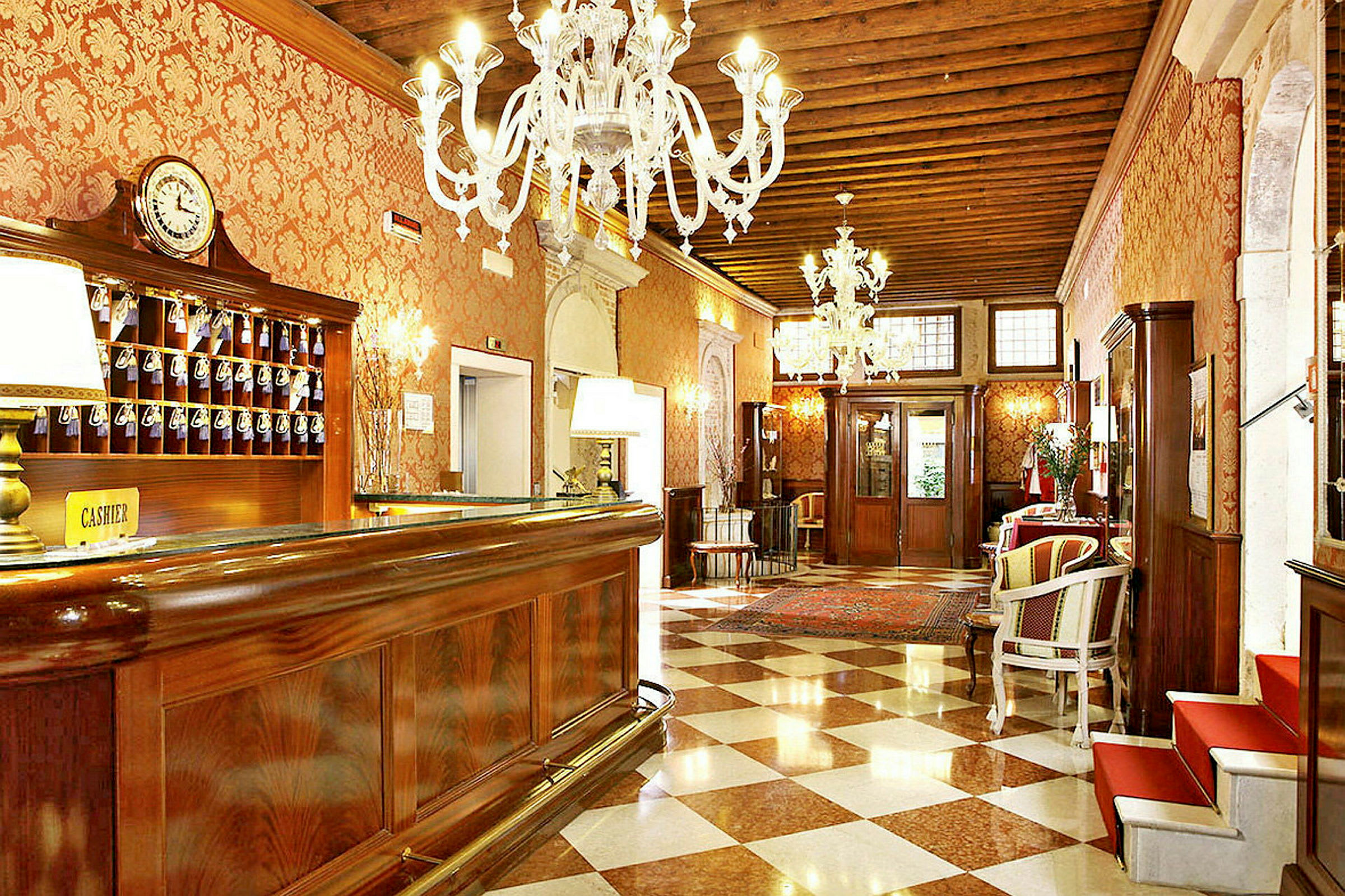 Hotellets lobby med reception, elegant indrettet med lysekroner og marmorgulv. (AI-genereret tekst)