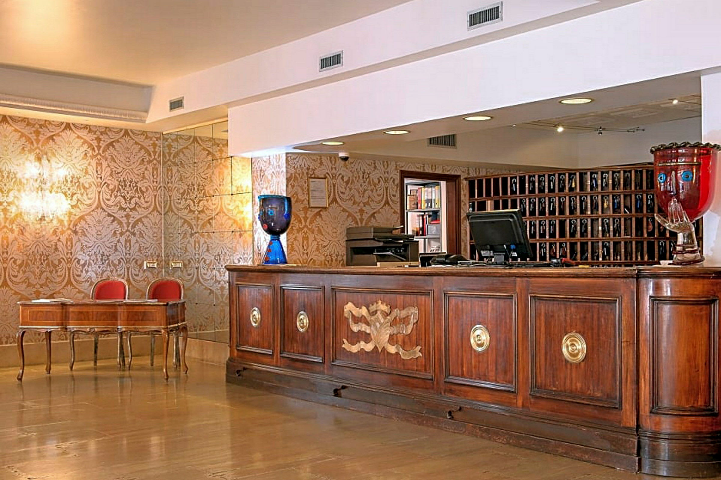 Reception i en hotellobby med et dekorativt skrivebord og en træskranke. (AI-genereret tekst)