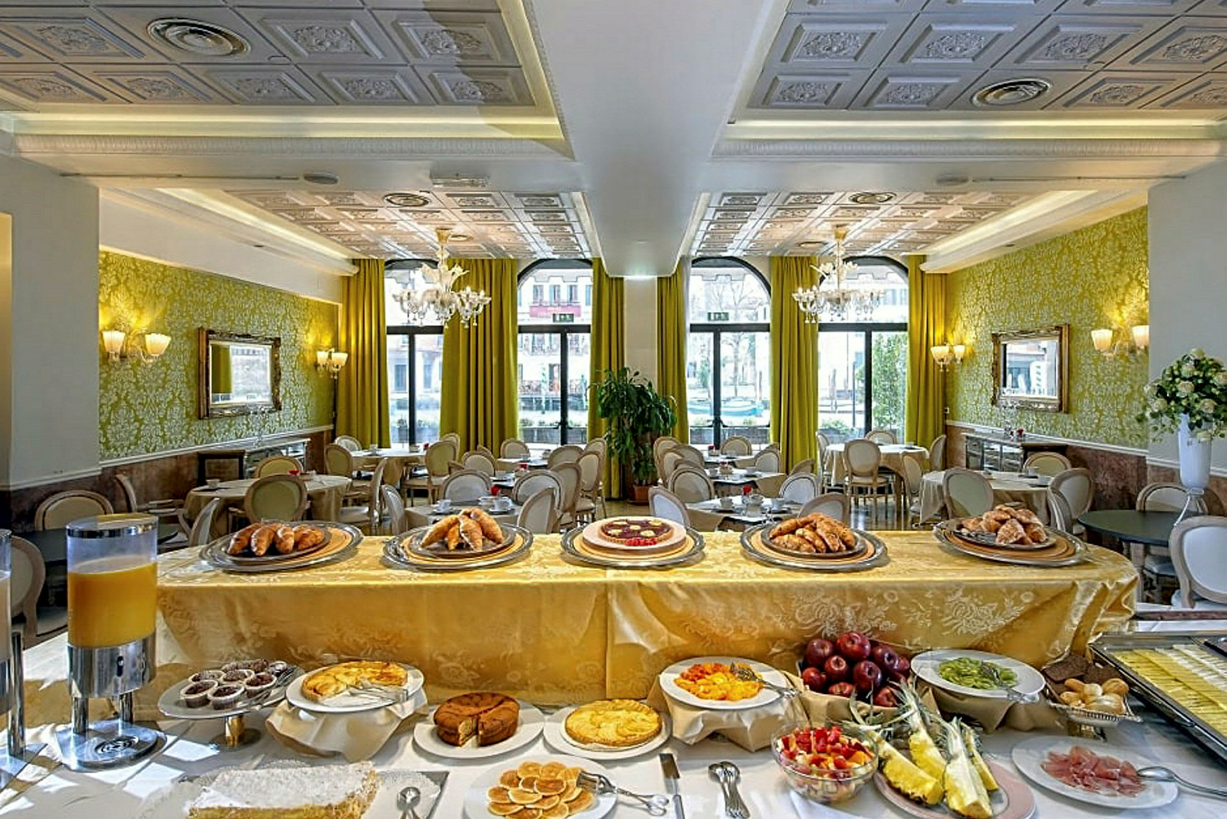 Et elegant spiseområde i en hotelrestaurant med en buffet med brød, kager og frisk frugt. (AI-genereret tekst)