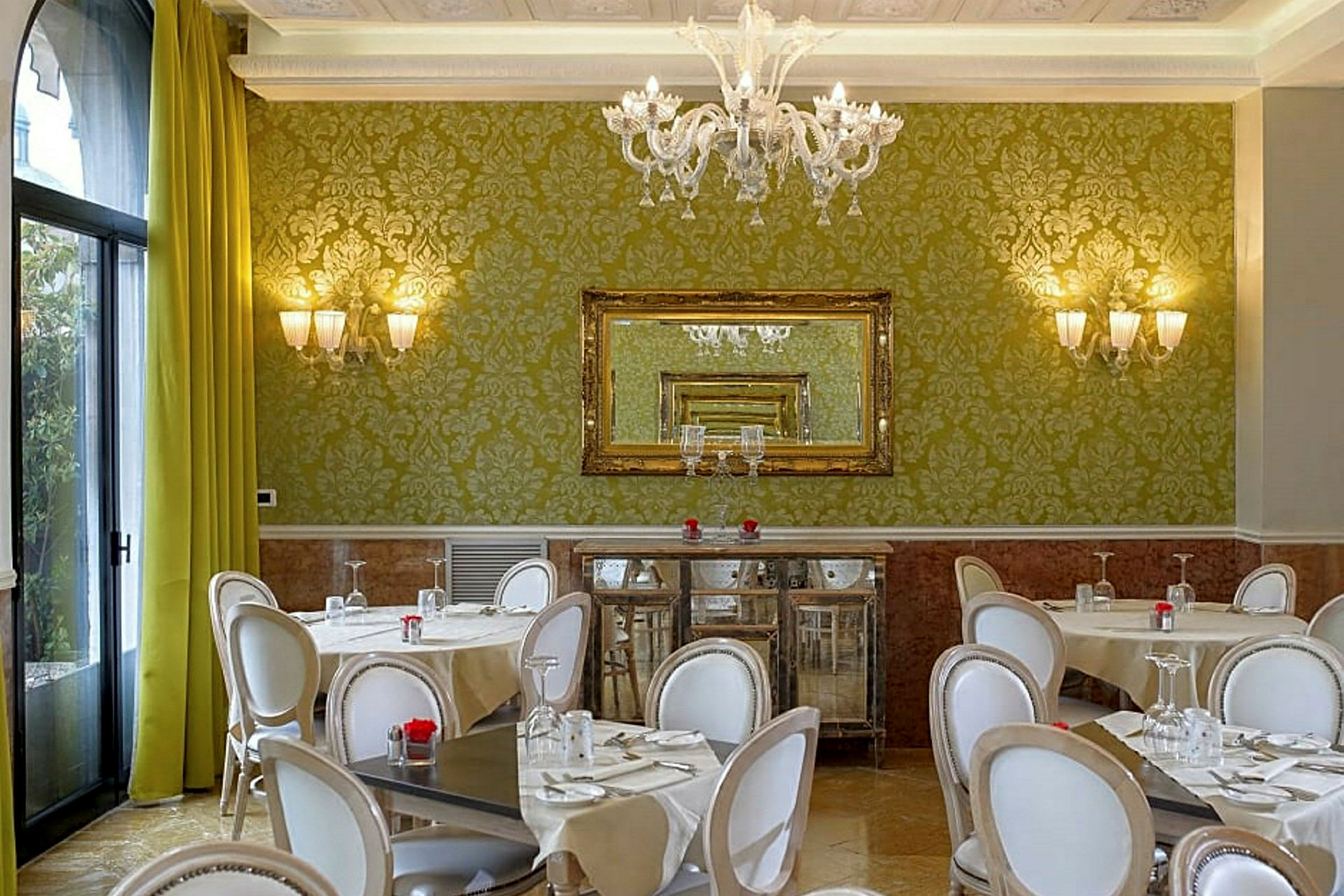 En restaurant med grønne vægge, stilfulde stole og borde med duge. (AI-genereret tekst)