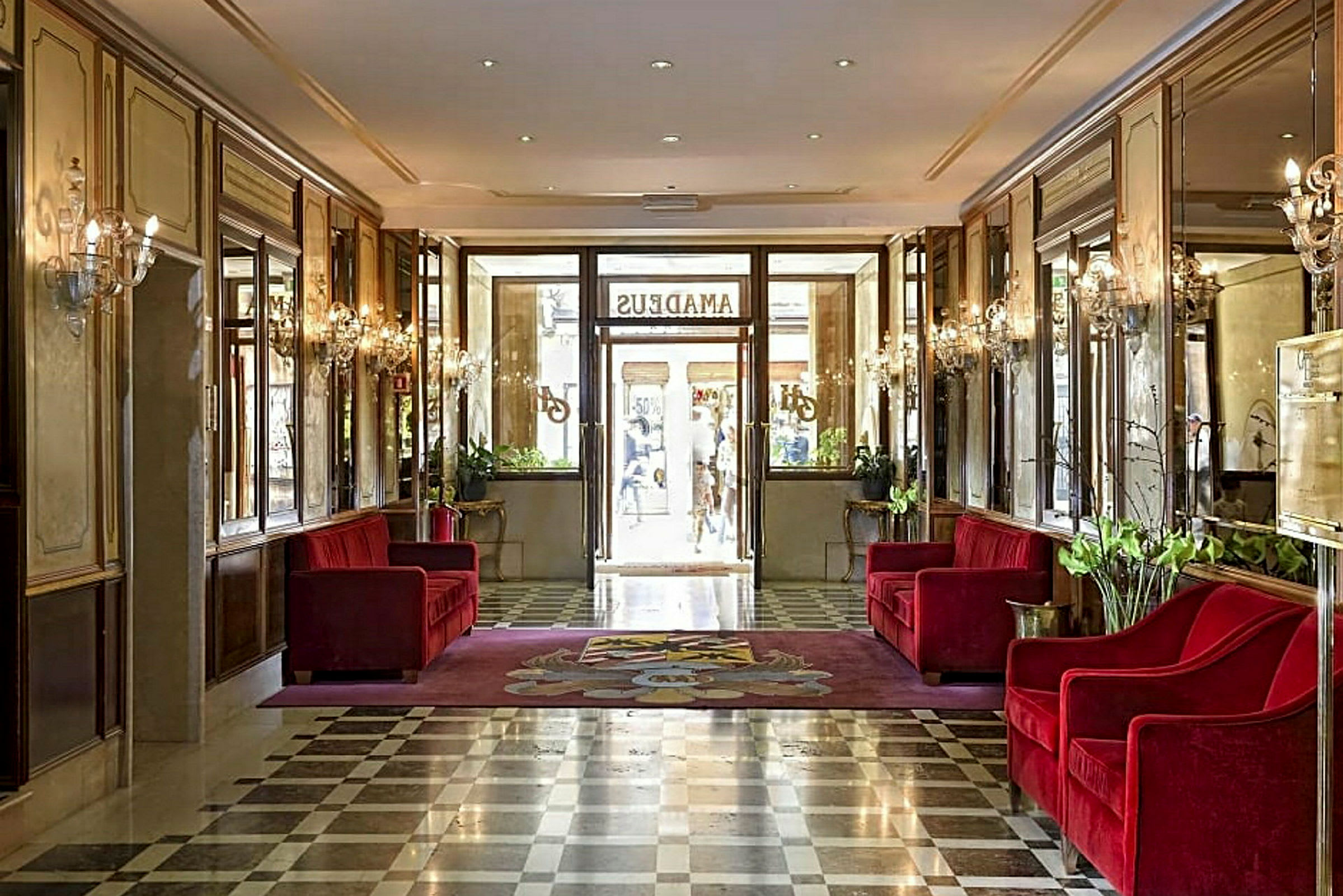 Hotellobby med røde sofaer og marmorgulv. (AI-genereret tekst)