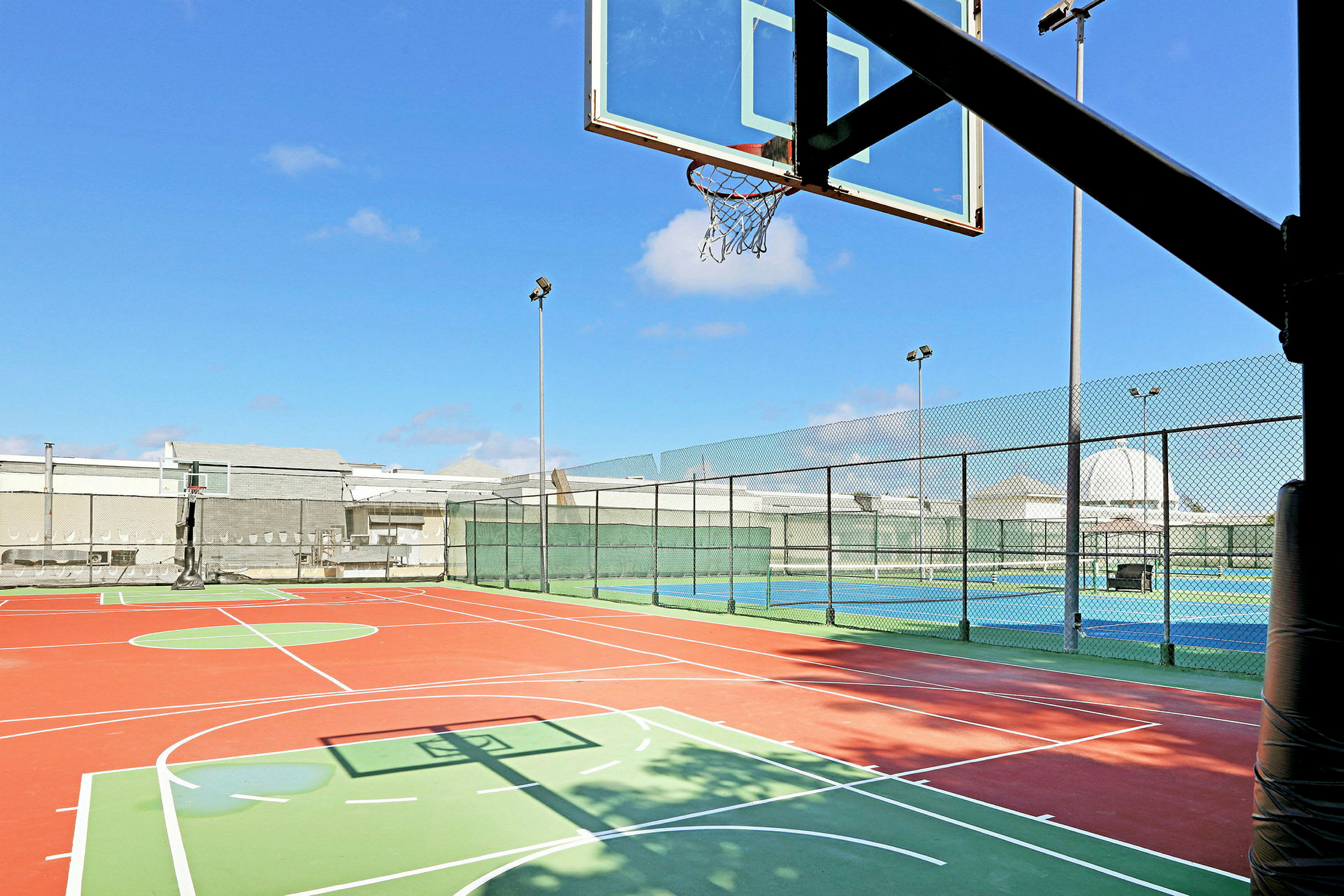 Udendørs basketballbane i klart vejr. (AI-genereret tekst)