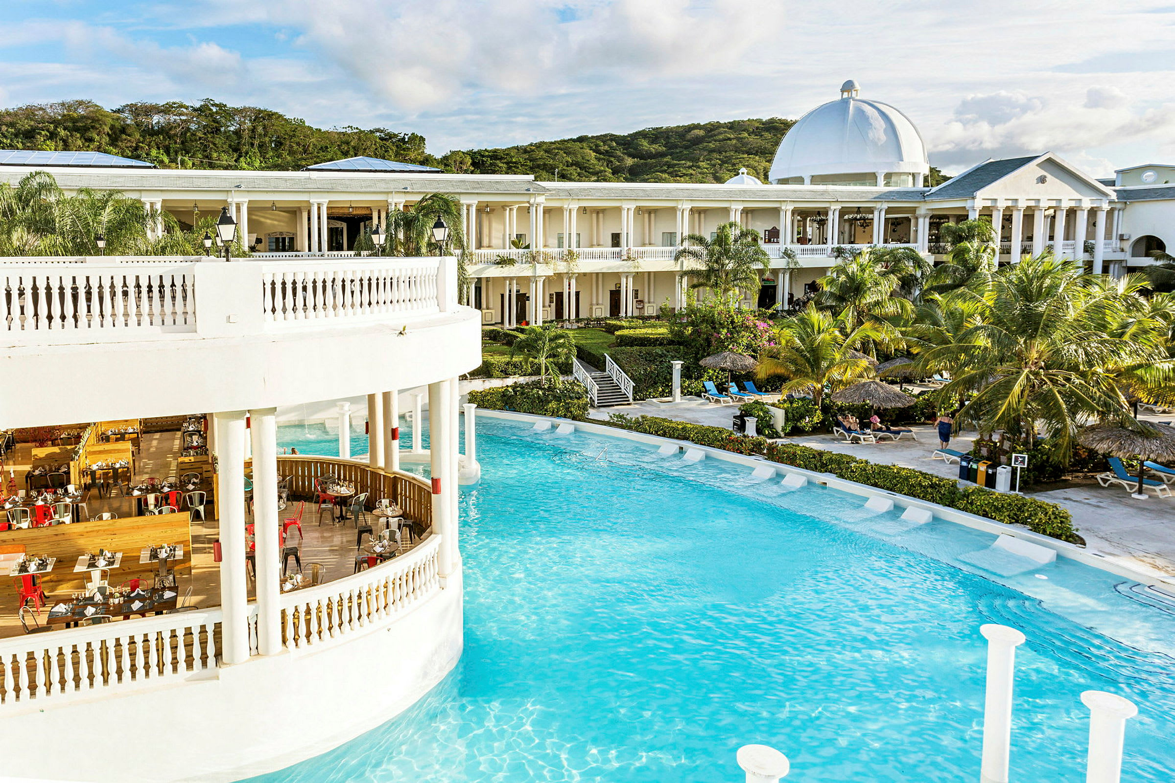Billede af hotel med pool, restaurant og omkringliggende have. (AI-genereret tekst)