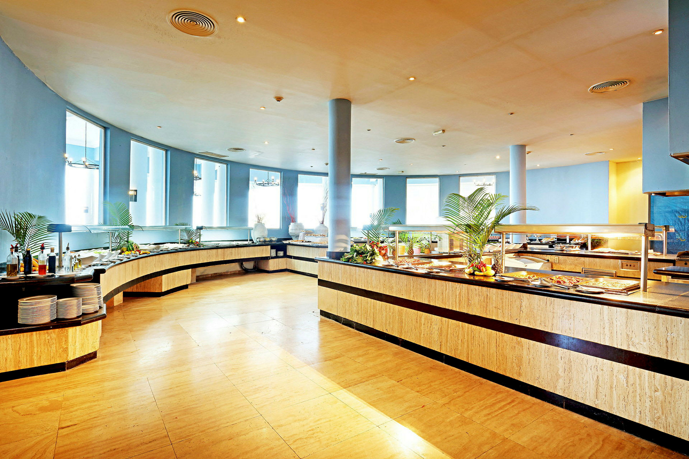 En lys og rummelig buffetrestaurant med mad opstillet på lange serveringsborde. (AI-genereret tekst)