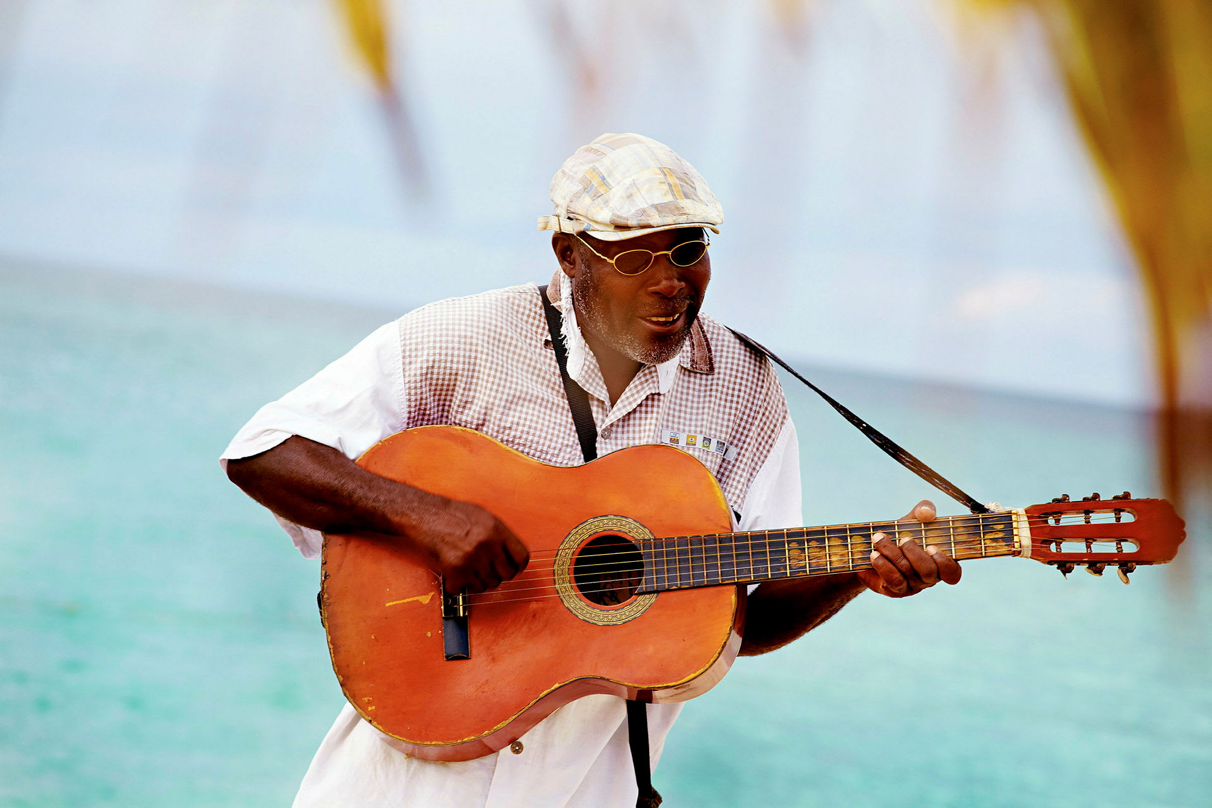 En person spiller guitar ved havet. (AI-genereret tekst)