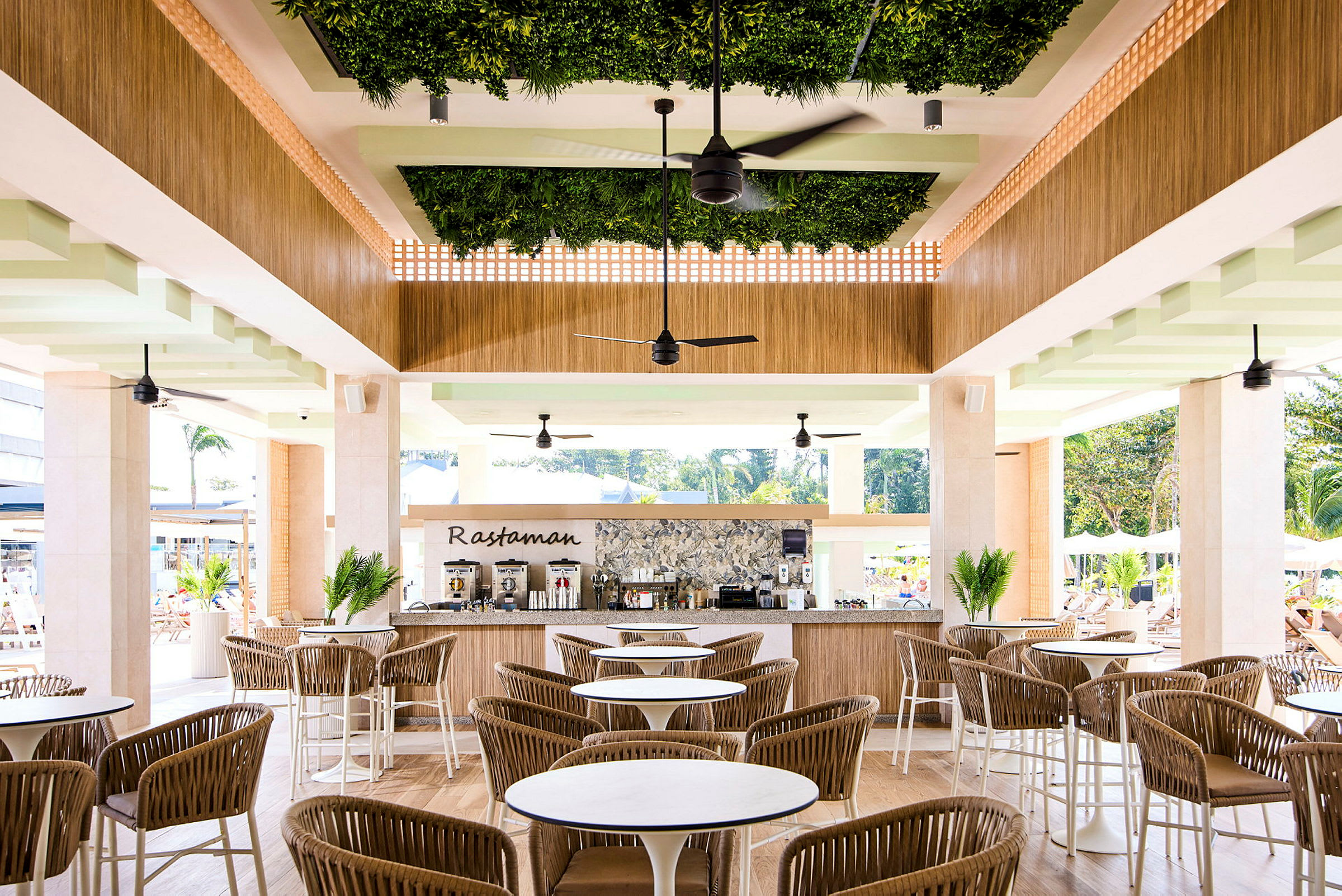 Restaurant med siddepladser og en bardisk dekoreret med grønne planter. (AI-genereret tekst)