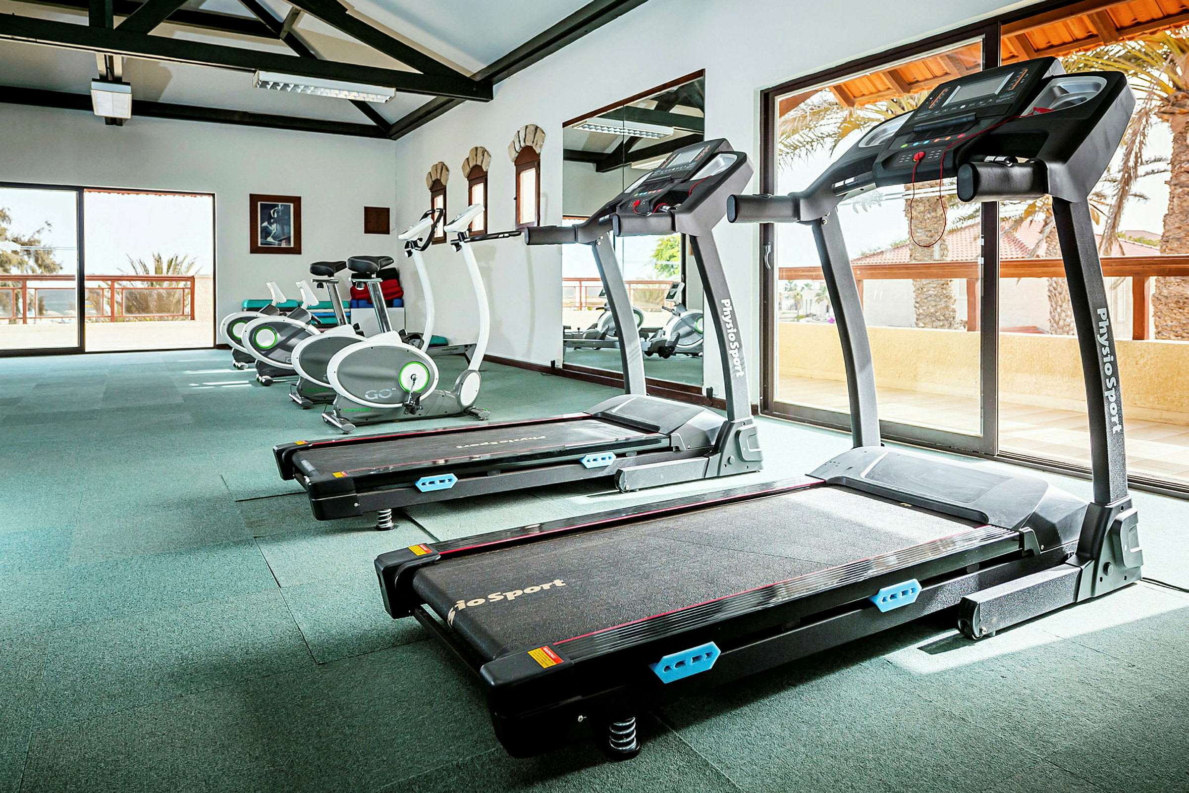 Fitnesscenter med træningsmaskiner, herunder løbebånd og motionscykler. (AI-genereret tekst)