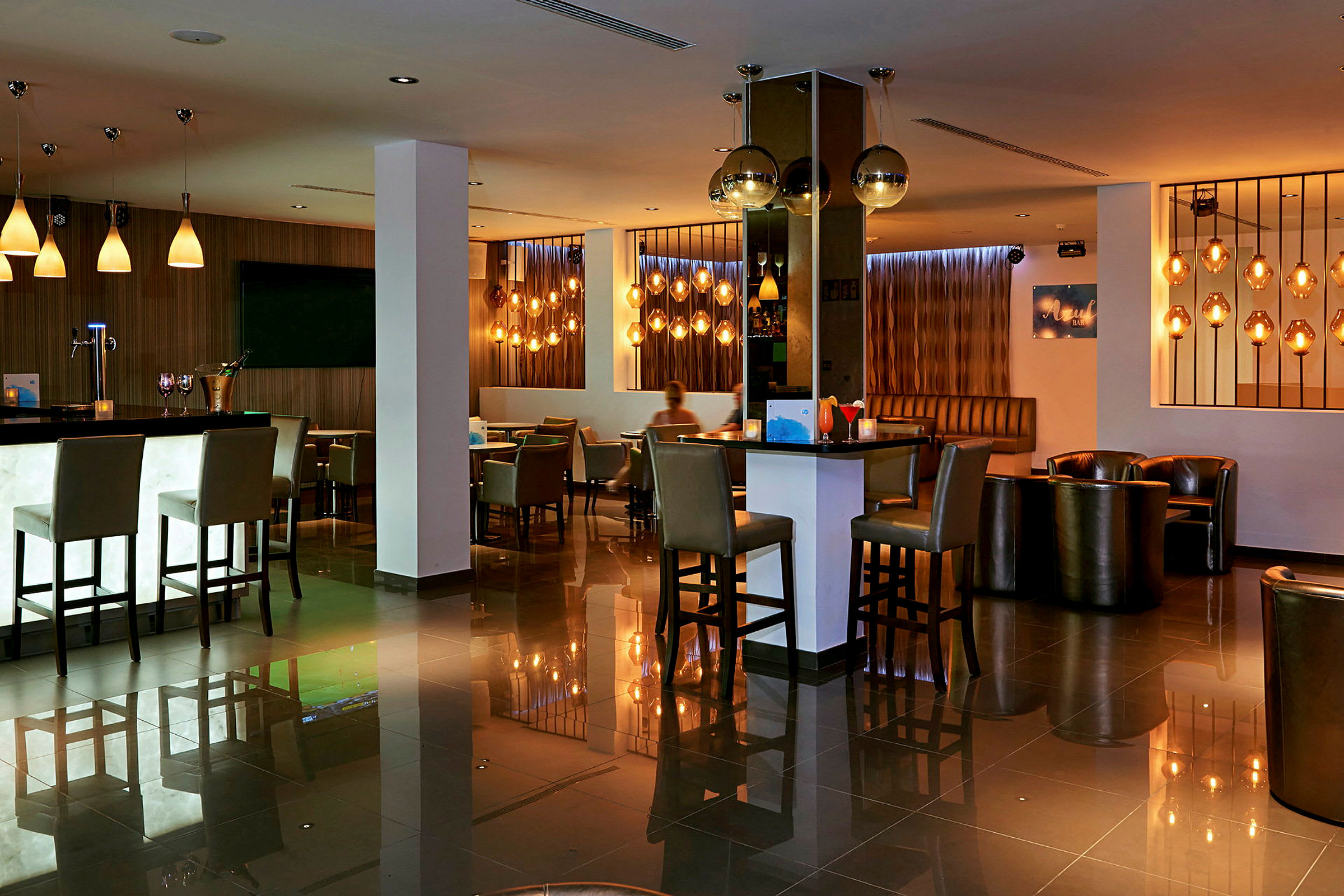 En moderne hotelbar med siddepladser og stemningsbelysning. (AI-genereret tekst)