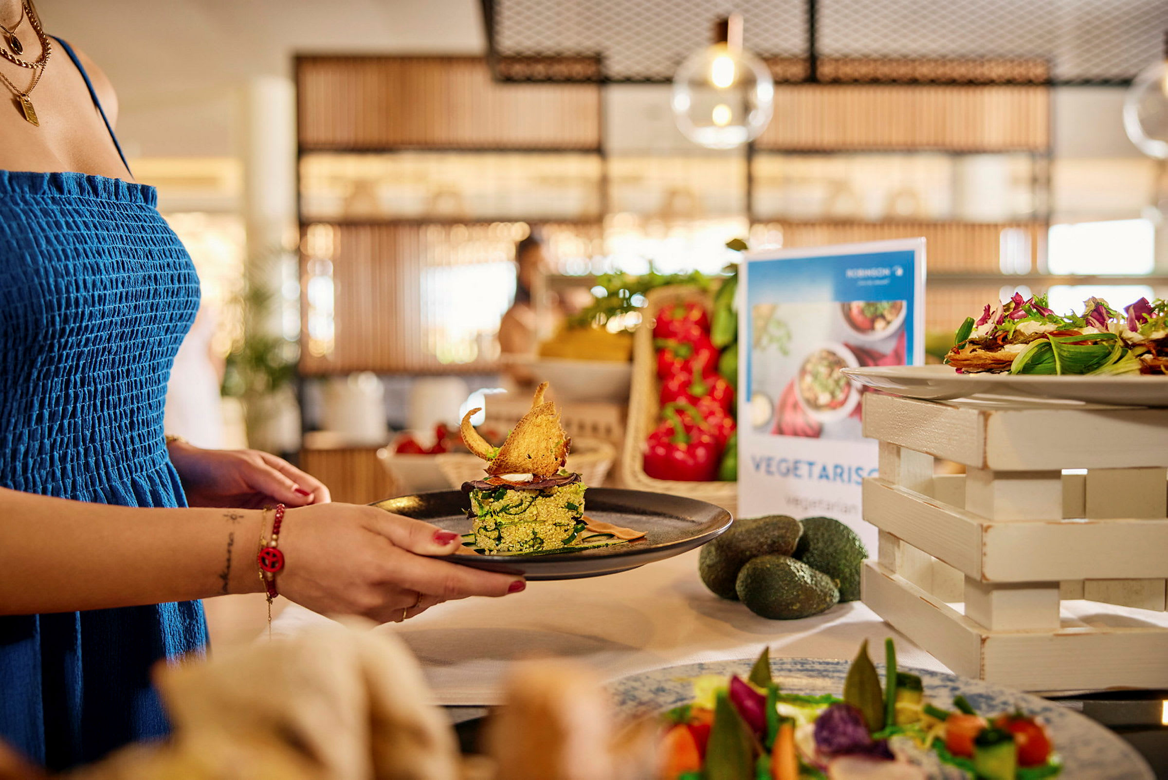 En person holder en tallerken med en vegetarisk ret på en buffet. (AI-genereret tekst)