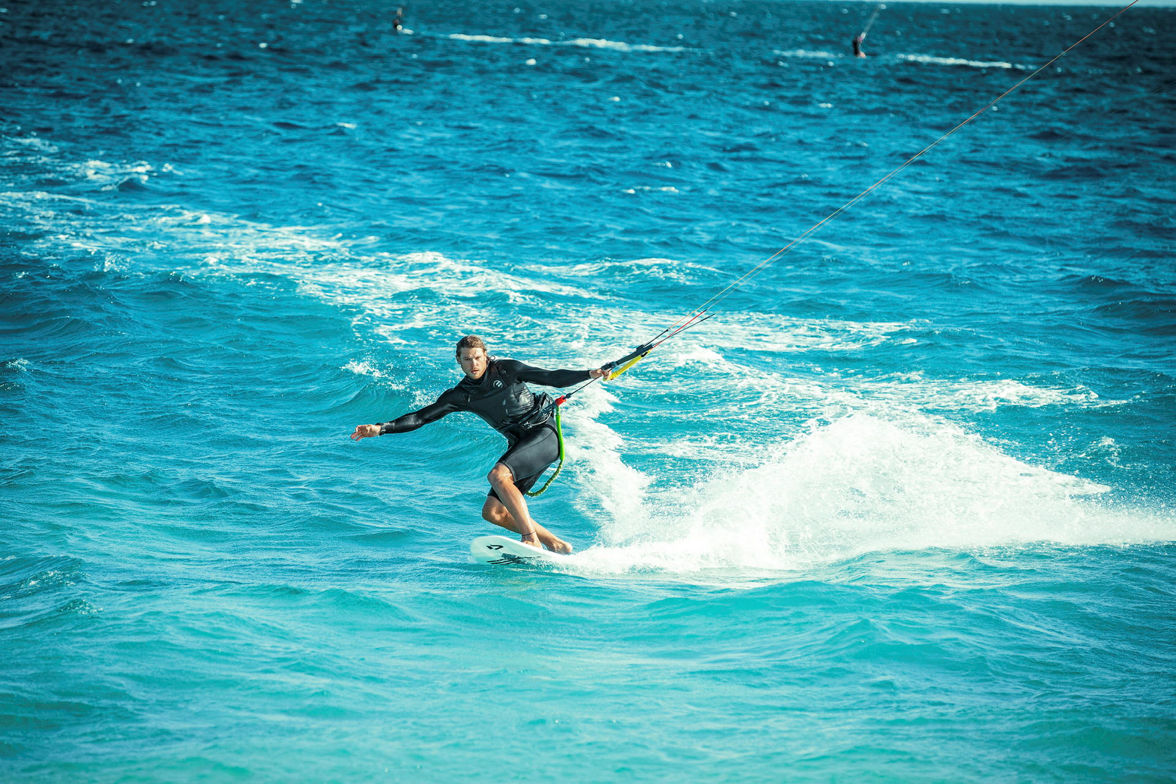 Person, der kite-surfer på et blåt hav. (AI-genereret tekst)