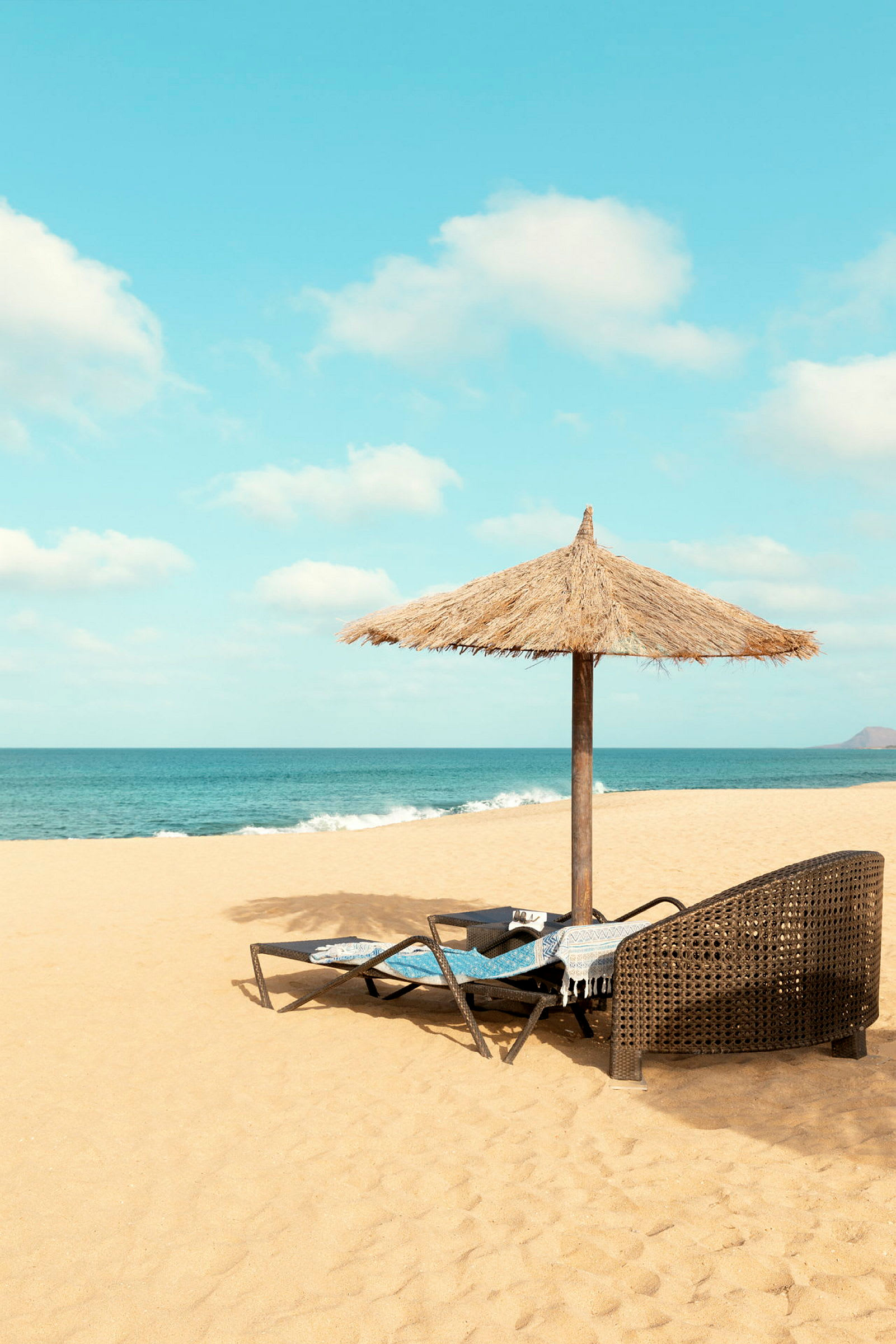 Strand med parasol og liggestole nær havet. (AI-genereret tekst)