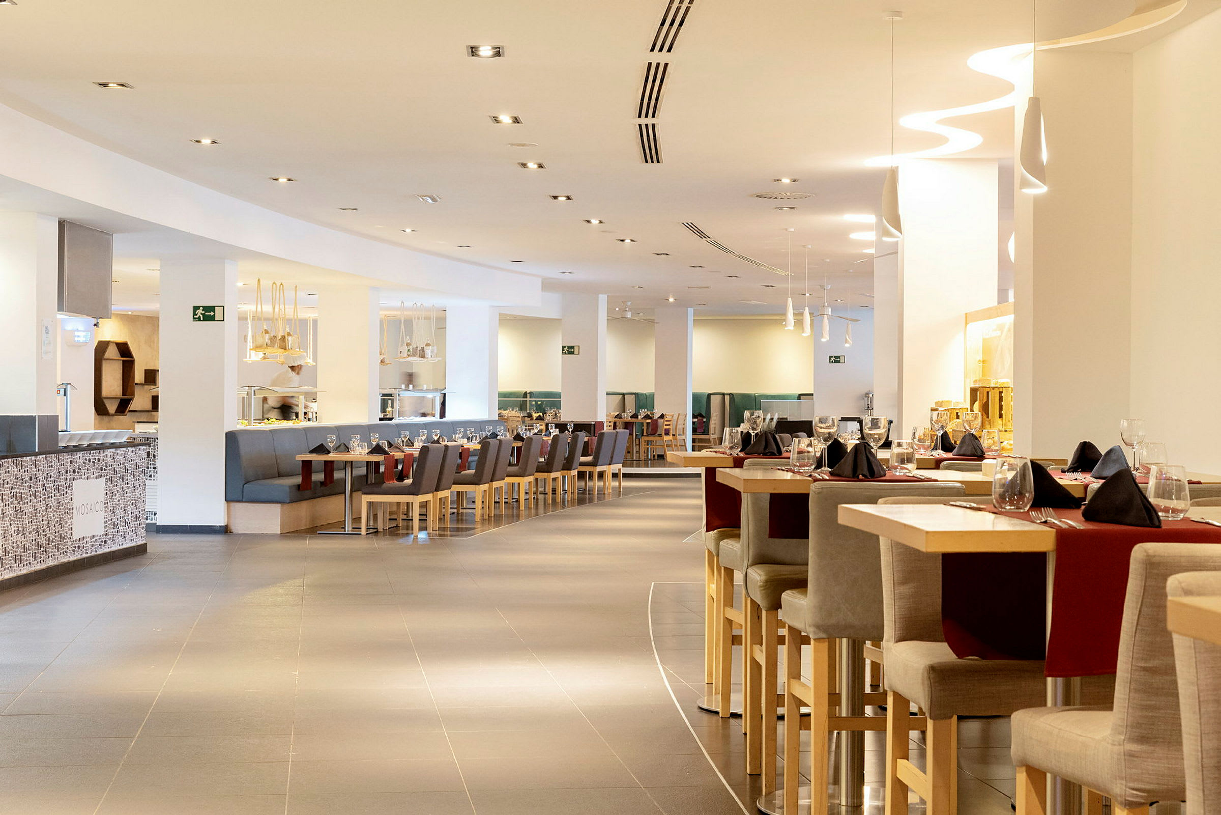 En moderne restaurant med siddepladser og borde pyntet til middag. (AI-genereret tekst)
