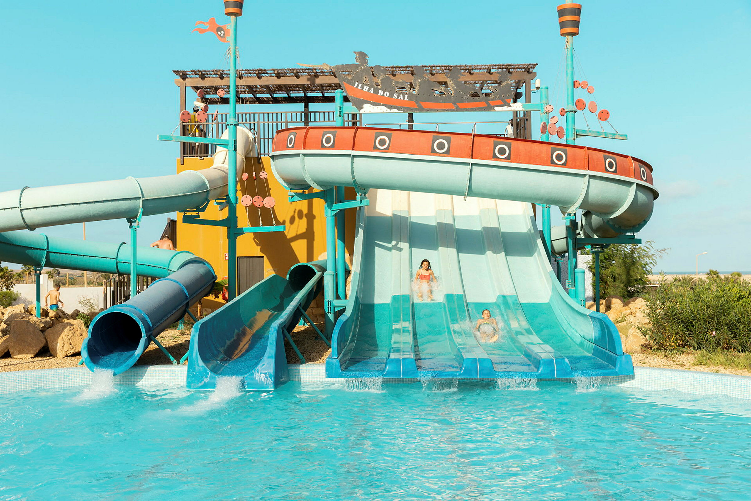 En vandpark med flere vandrutsjebaner og en pool. (AI-genereret tekst)