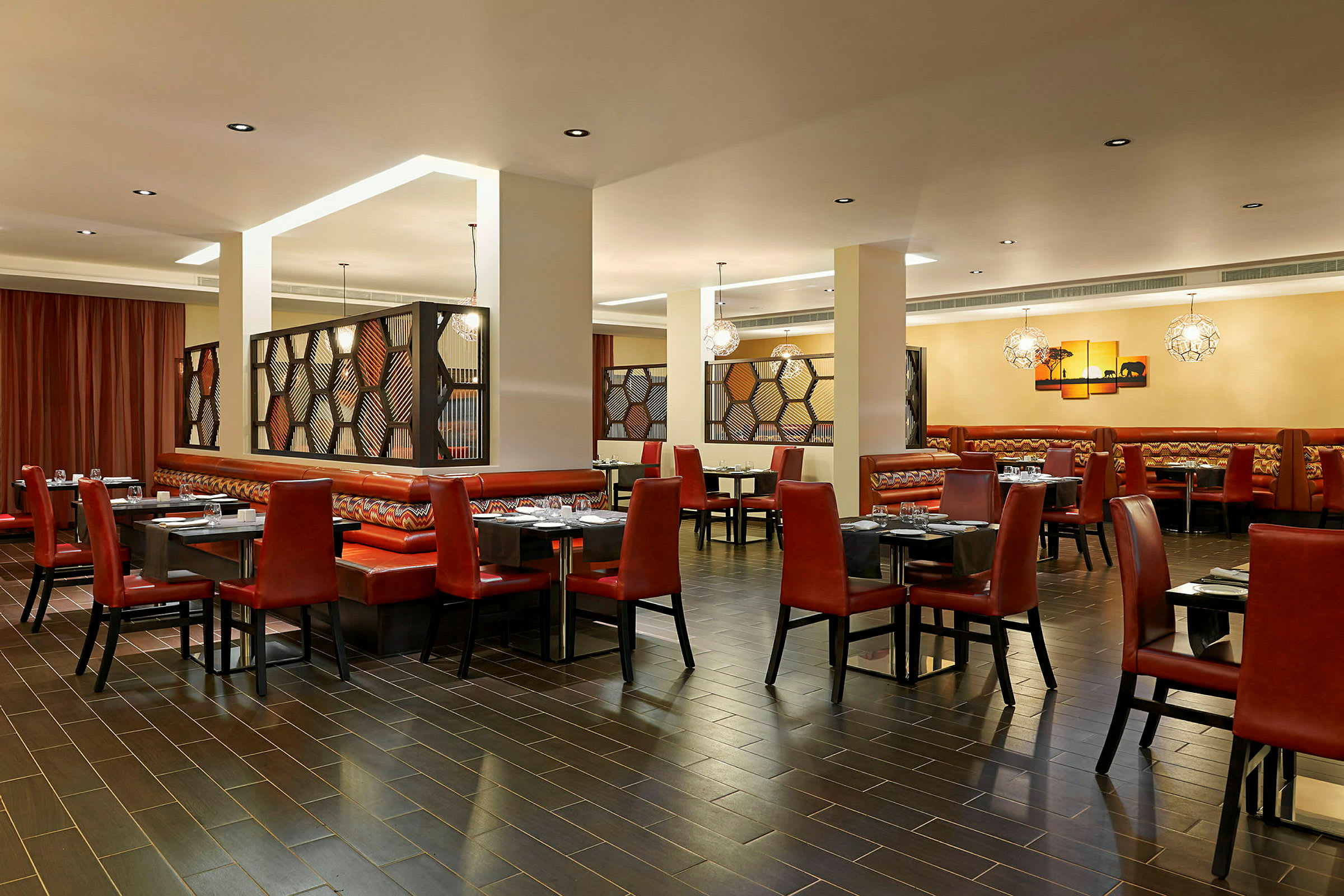 Restaurant med røde stole, borde og belysning. (AI-genereret tekst)
