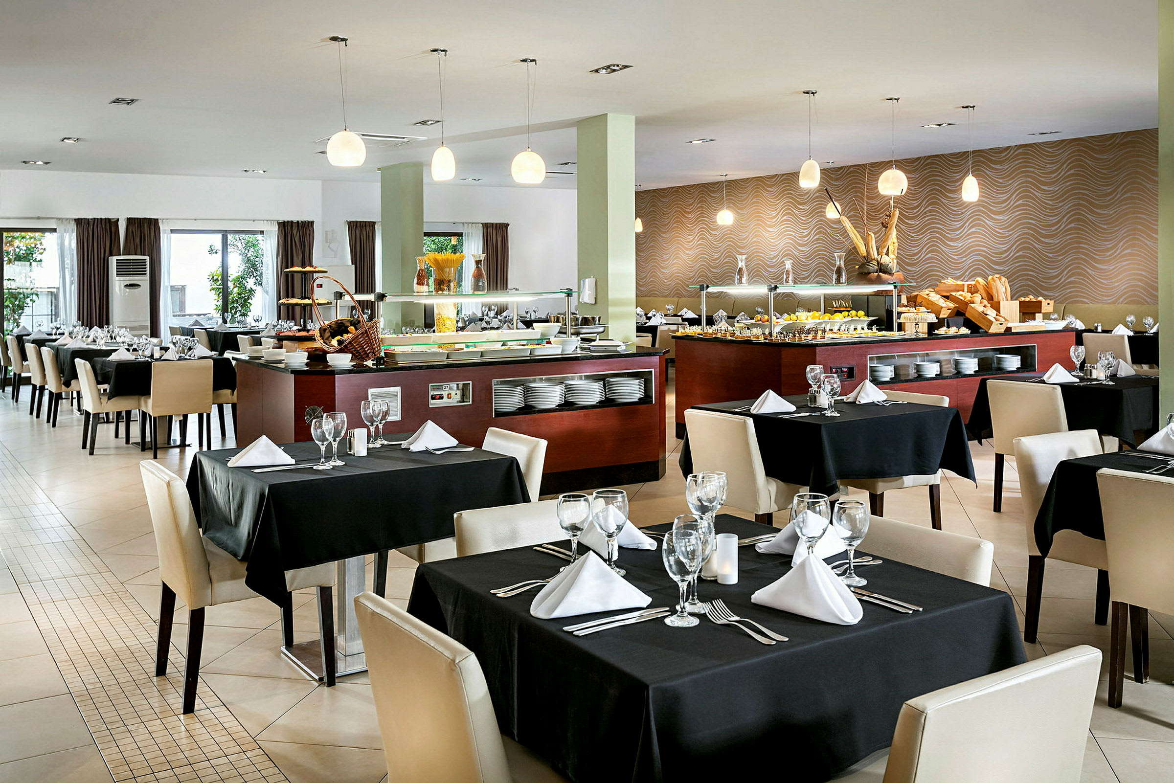 Restaurant med opdækkede borde og buffetområde. (AI-genereret tekst)