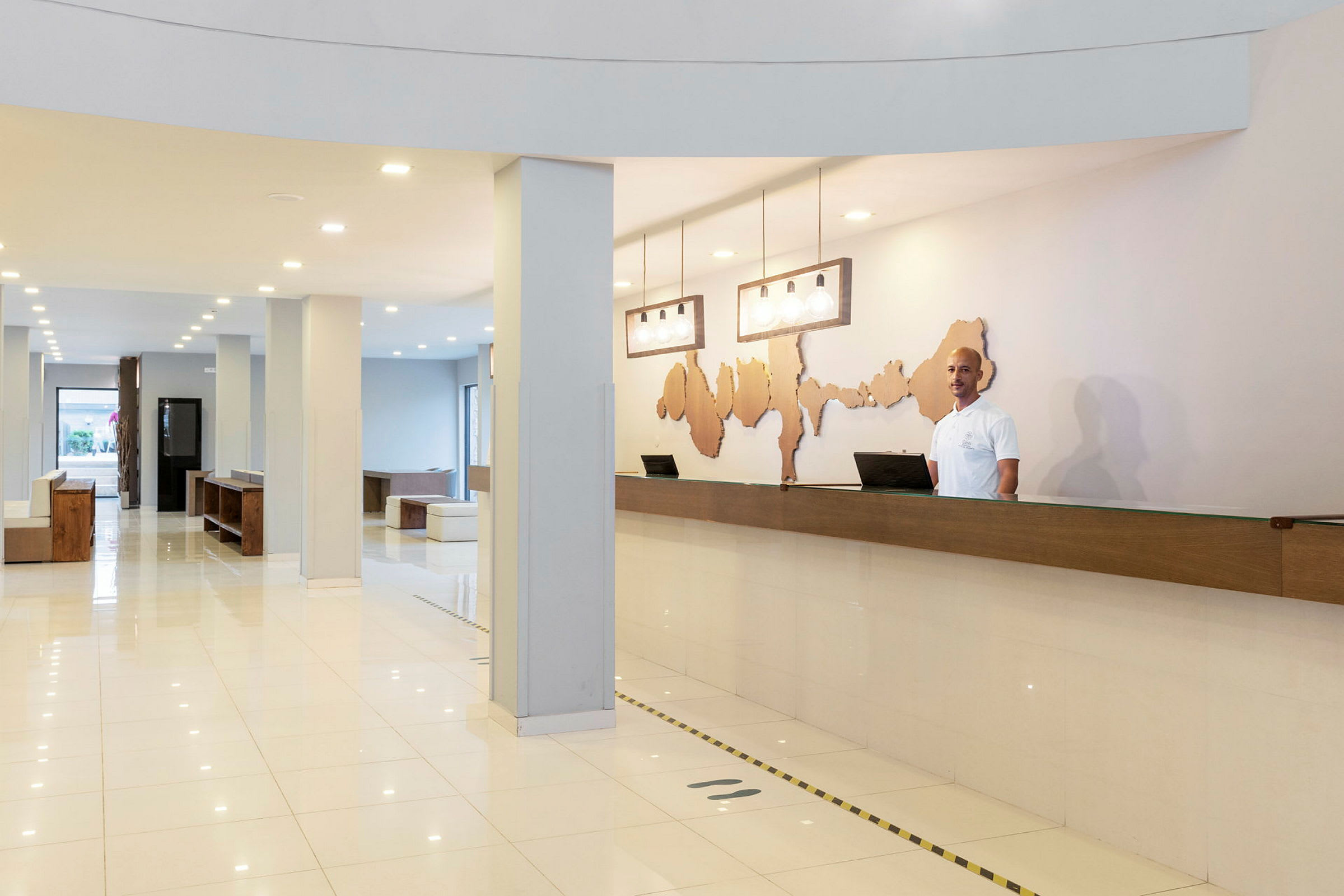 En reception med skrivebord og dekorativ vægkunst i et lyst og moderne hotel. (AI-genereret tekst)