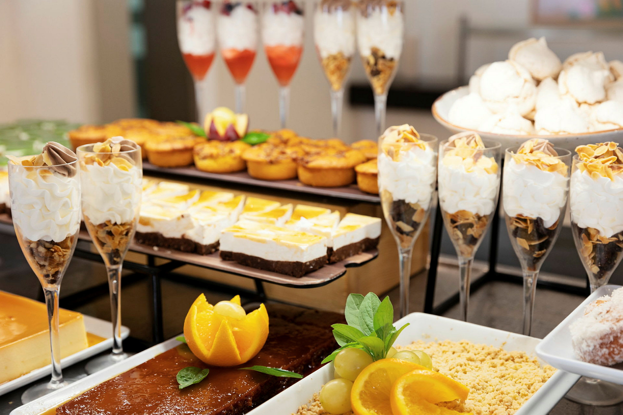 Billede af et dessertbord med forskellige søde sager, herunder glas med fløde, kager og frugter. (AI-genereret tekst)
