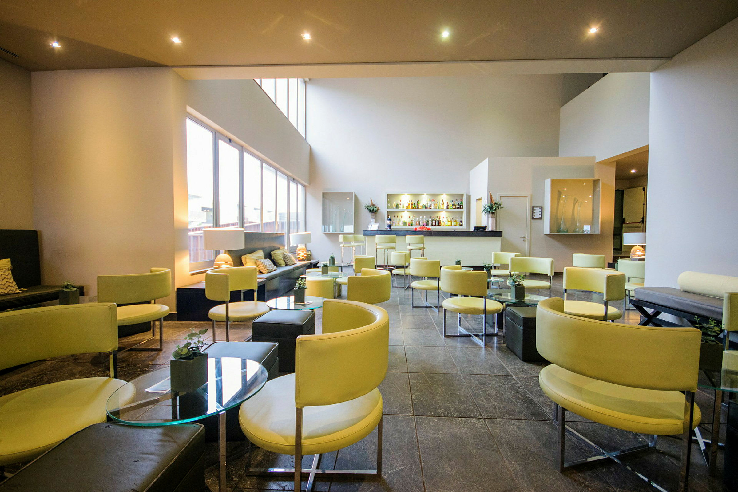 Moderne lounge med lyse møbler og bar. (AI-genereret tekst)