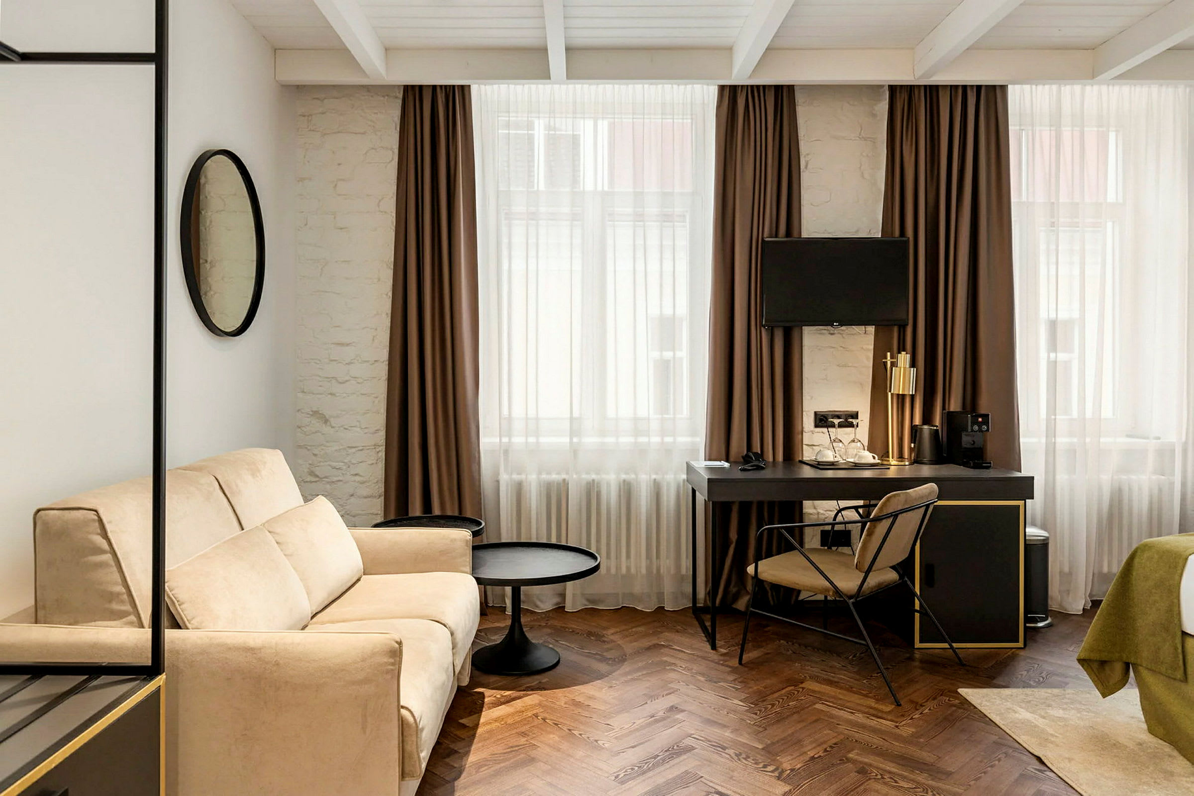 Moderne møbleret hotelværelse med sofa, skrivebord og TV. (AI-genereret tekst)