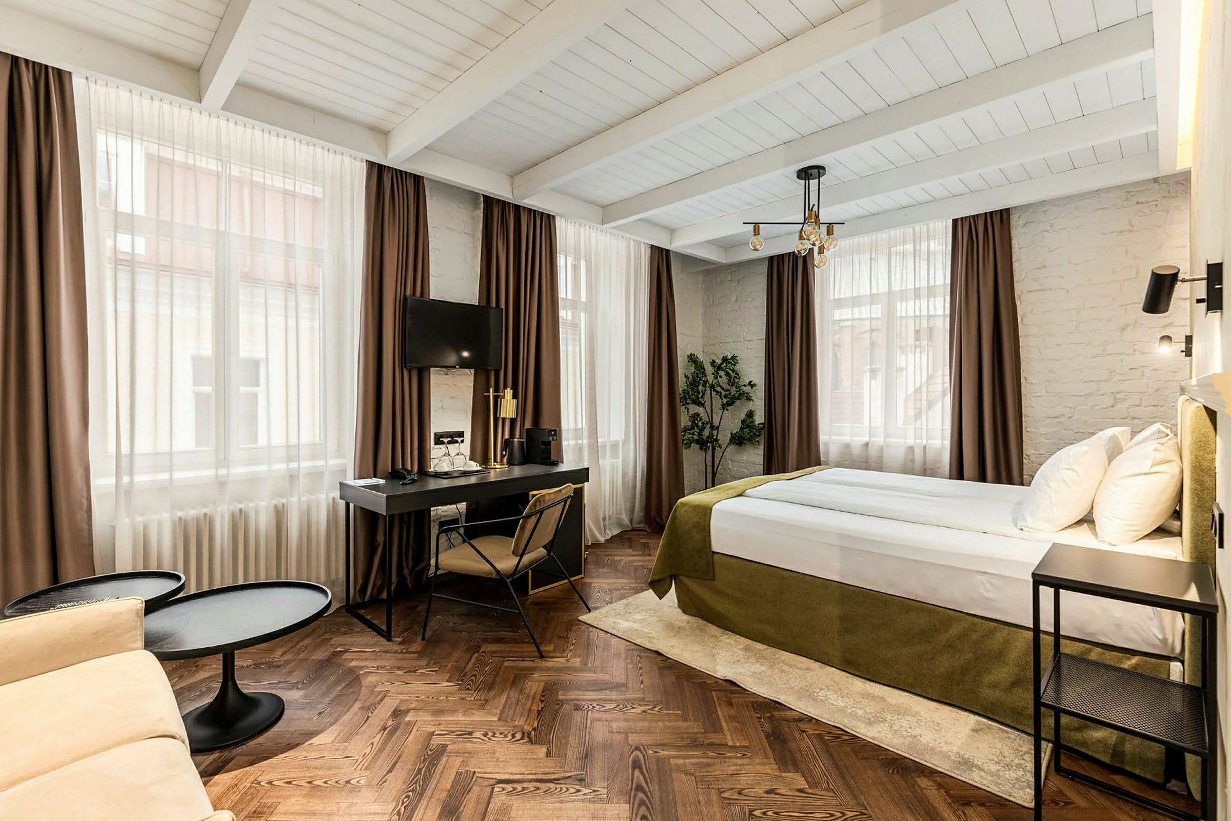 Hotelværelse med seng, skrivebord og siddeområde. (AI-genereret tekst)