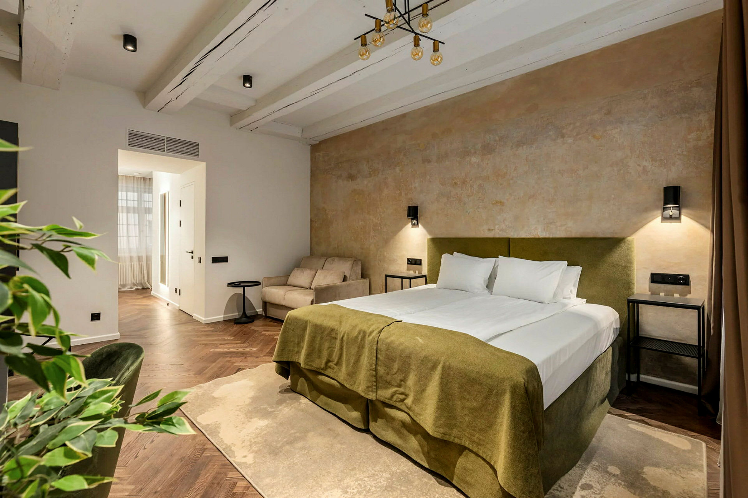 Et soveværelse med en dobbeltseng, en sofa og en rustik vægbelægning. (AI-genereret tekst)