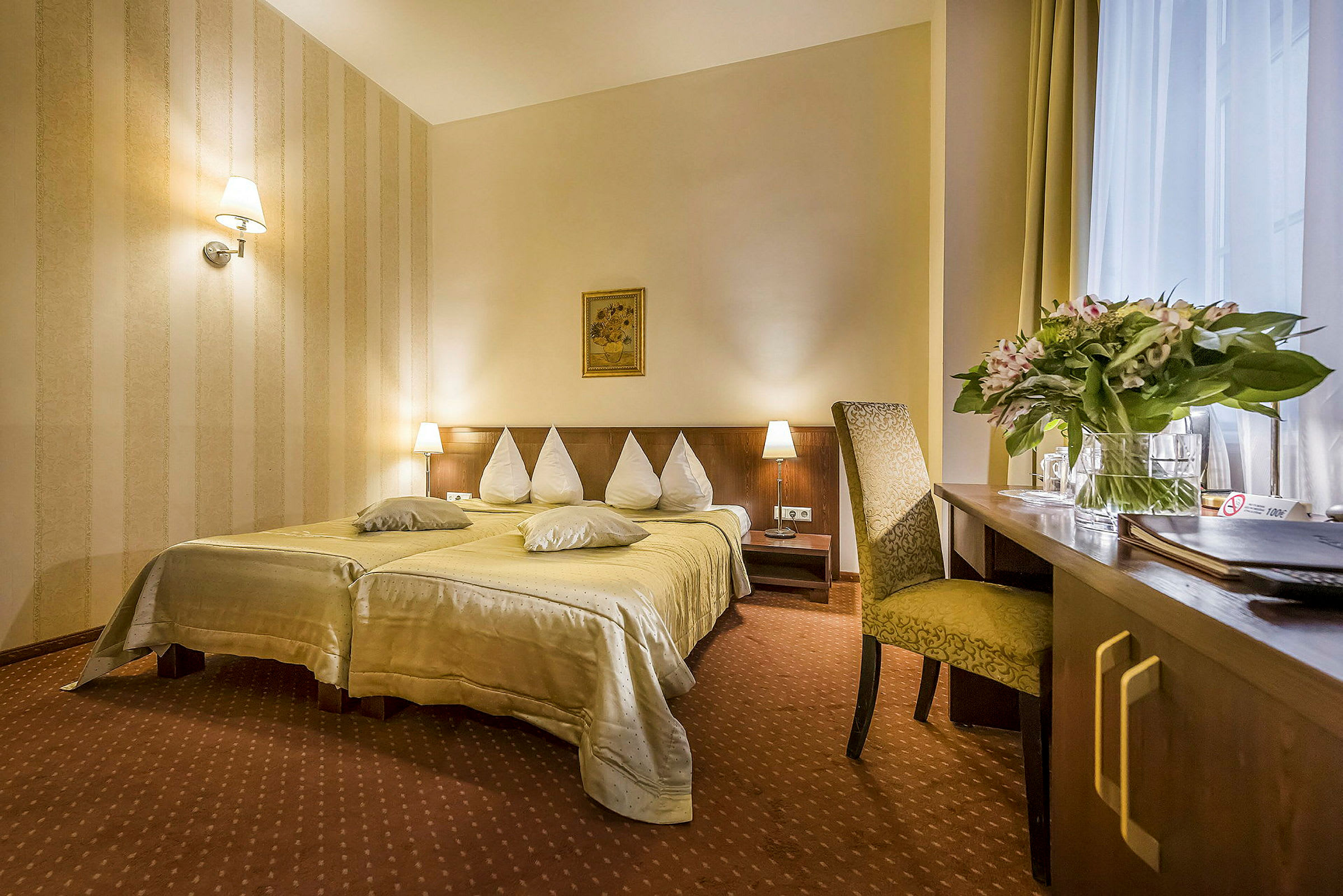 Hotelværelse med en dobbeltseng, natborde og et skrivebord med stol. (AI-genereret tekst)