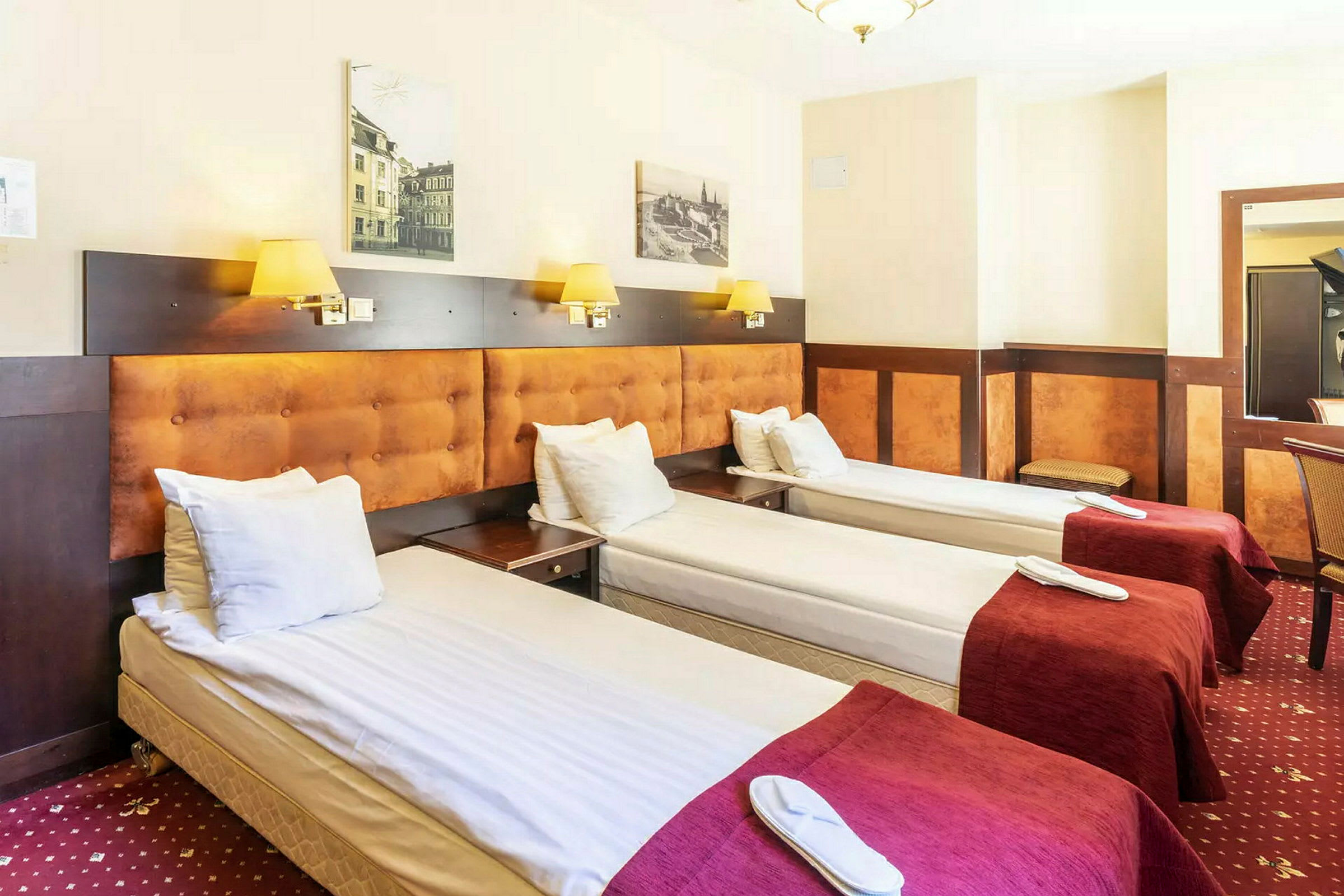 Tre enkeltsenge placeret på række i et hotelværelse. (AI-genereret tekst)