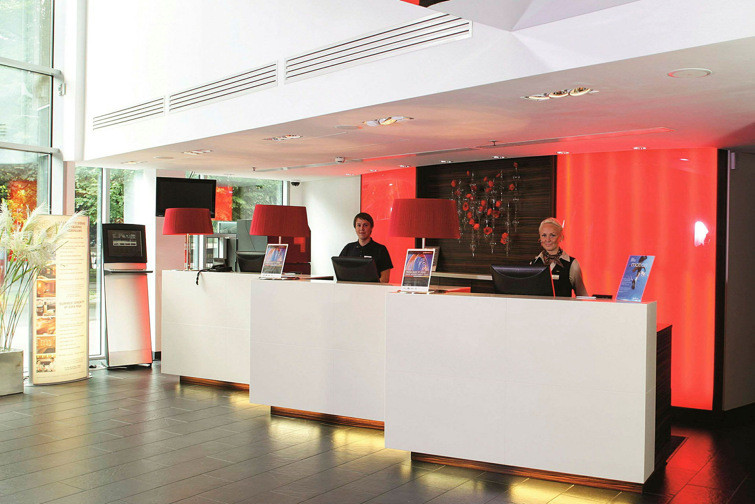 Reception med to receptionsdiske og rød baggrundsbelysning. (AI-genereret tekst)