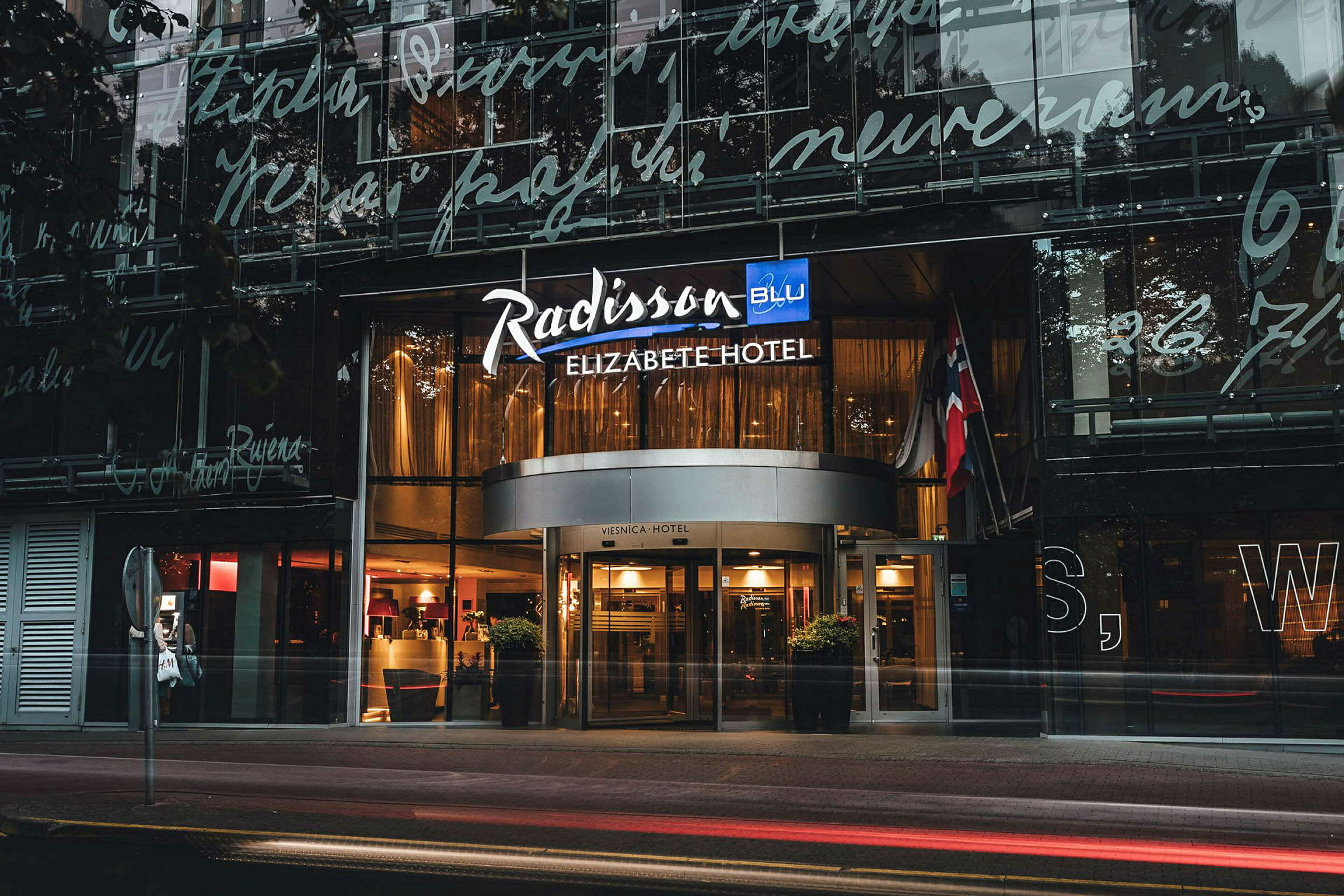 Indgangen til et hotel med skilt, der står "Radisson Blu Elizabete Hotel". (AI-genereret tekst)
