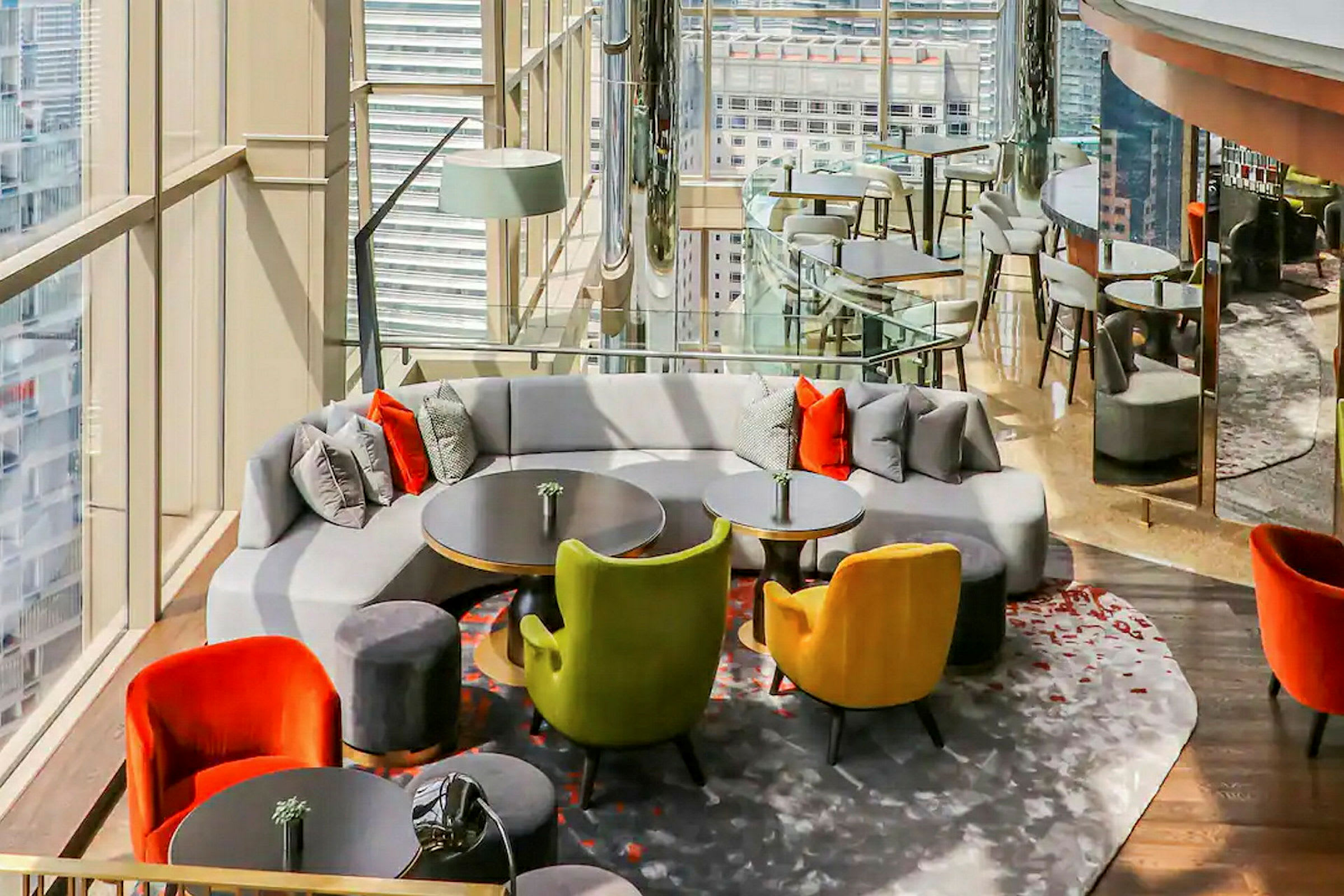 En elegant lounge med moderne møbler, puder og udsigt gennem store glasvinduer. (AI-genereret tekst)
