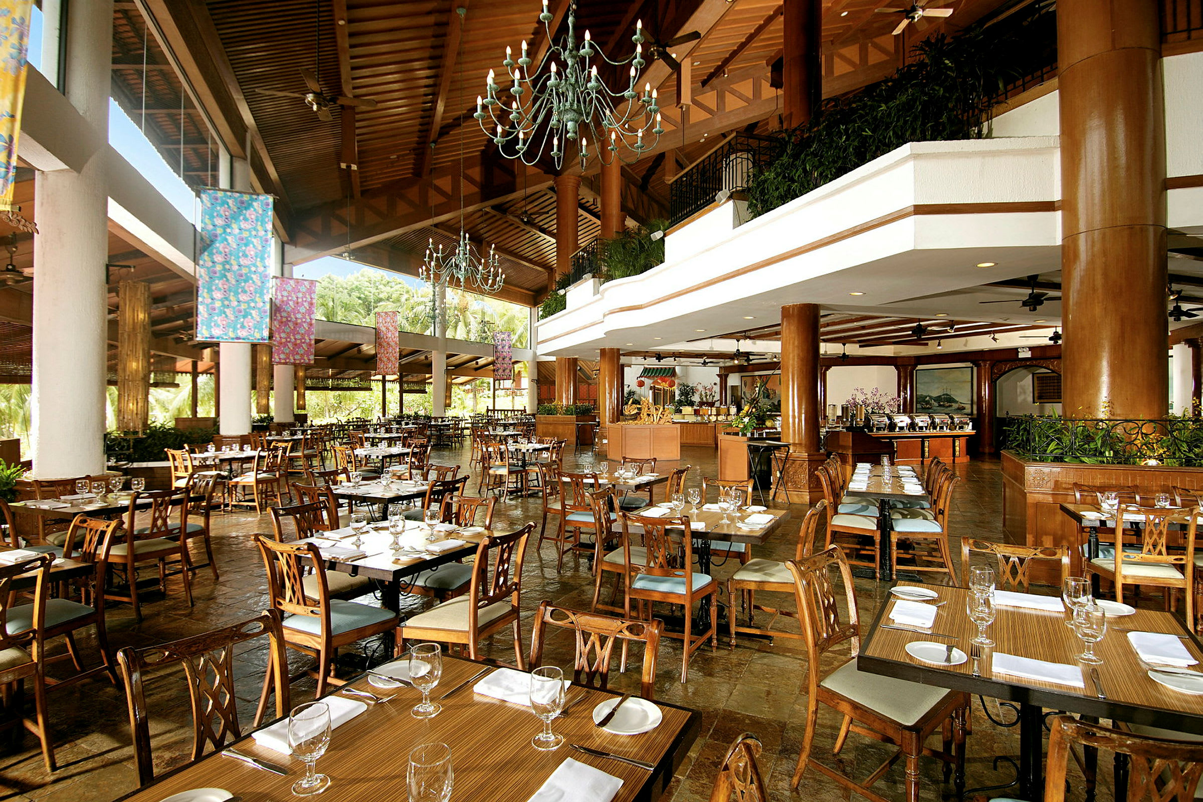 Restaurant med dækkede træborde og stole, store vinduer og loft med belysning. (AI-genereret tekst)