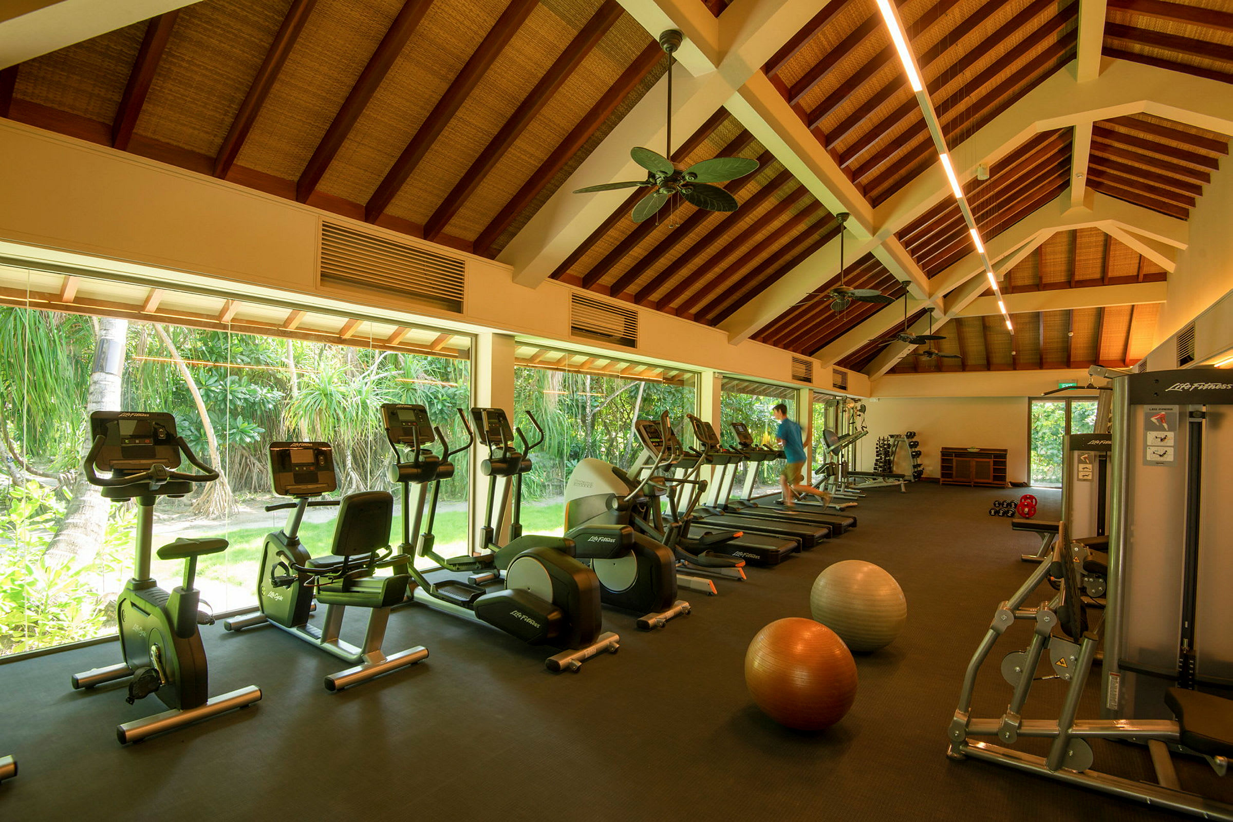 Et fitnesscenter med træningsmaskiner og store vinduer. (AI-genereret tekst)
