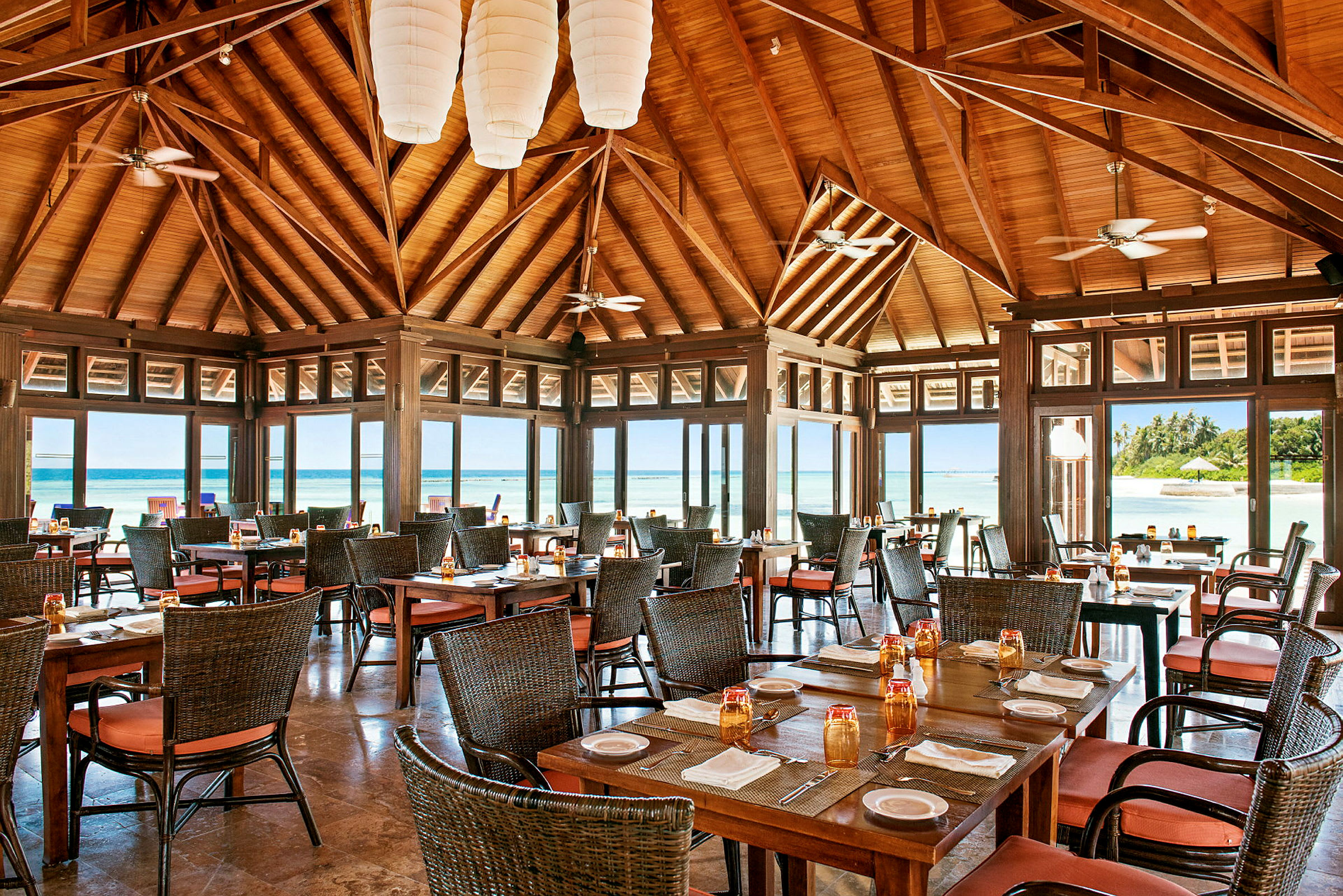 Restaurant med trætak og udsigt over stranden. (AI-genereret tekst)