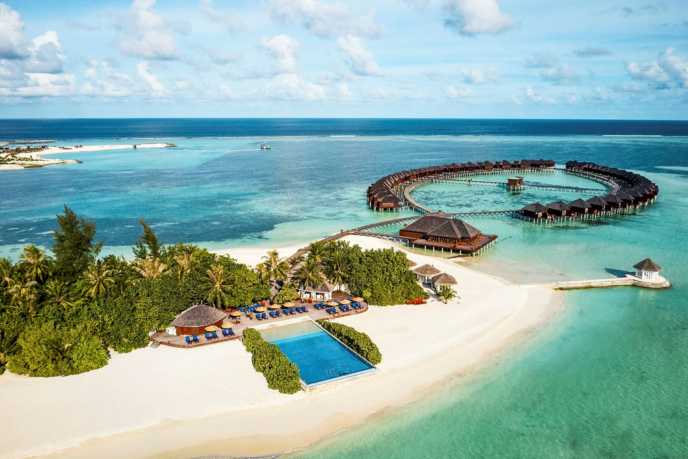 Luftfoto af en tropisk kyst med sandstrand, hav og overnattingsbungalower. (AI-genereret tekst)