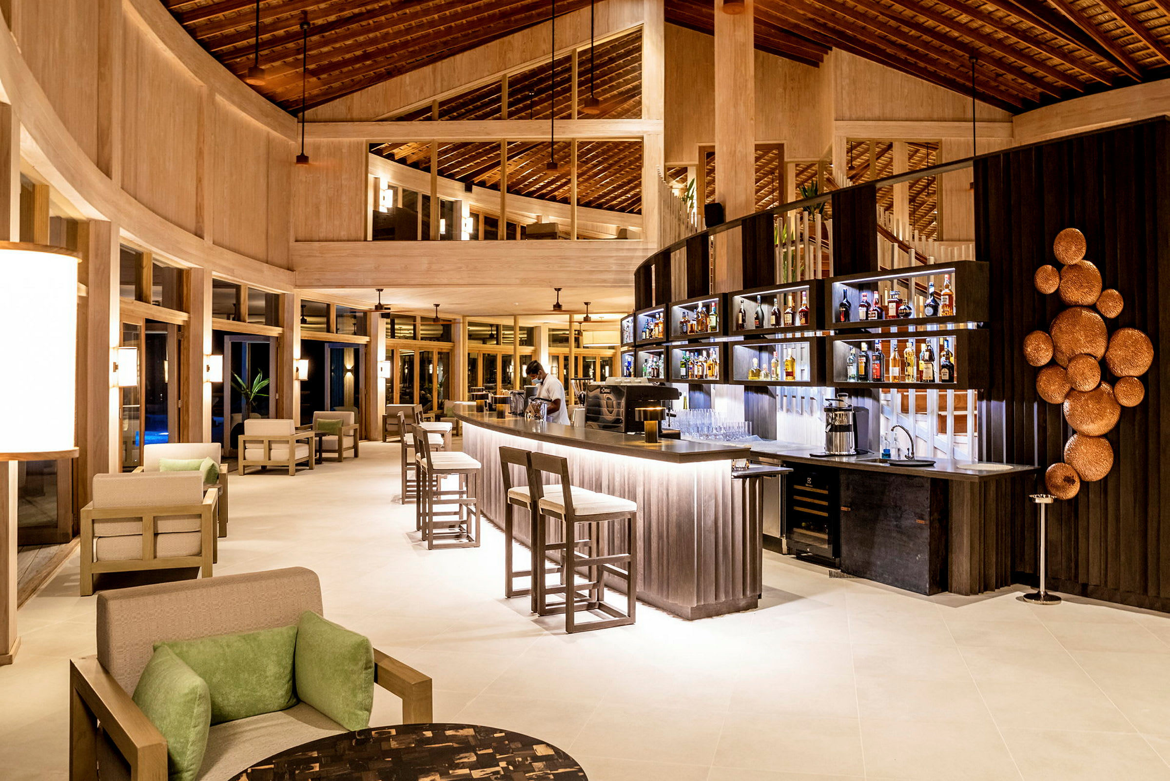 Interiør af en moderne lobby med bar, siddepladser og dekorativ belysning. (AI-genereret tekst)
