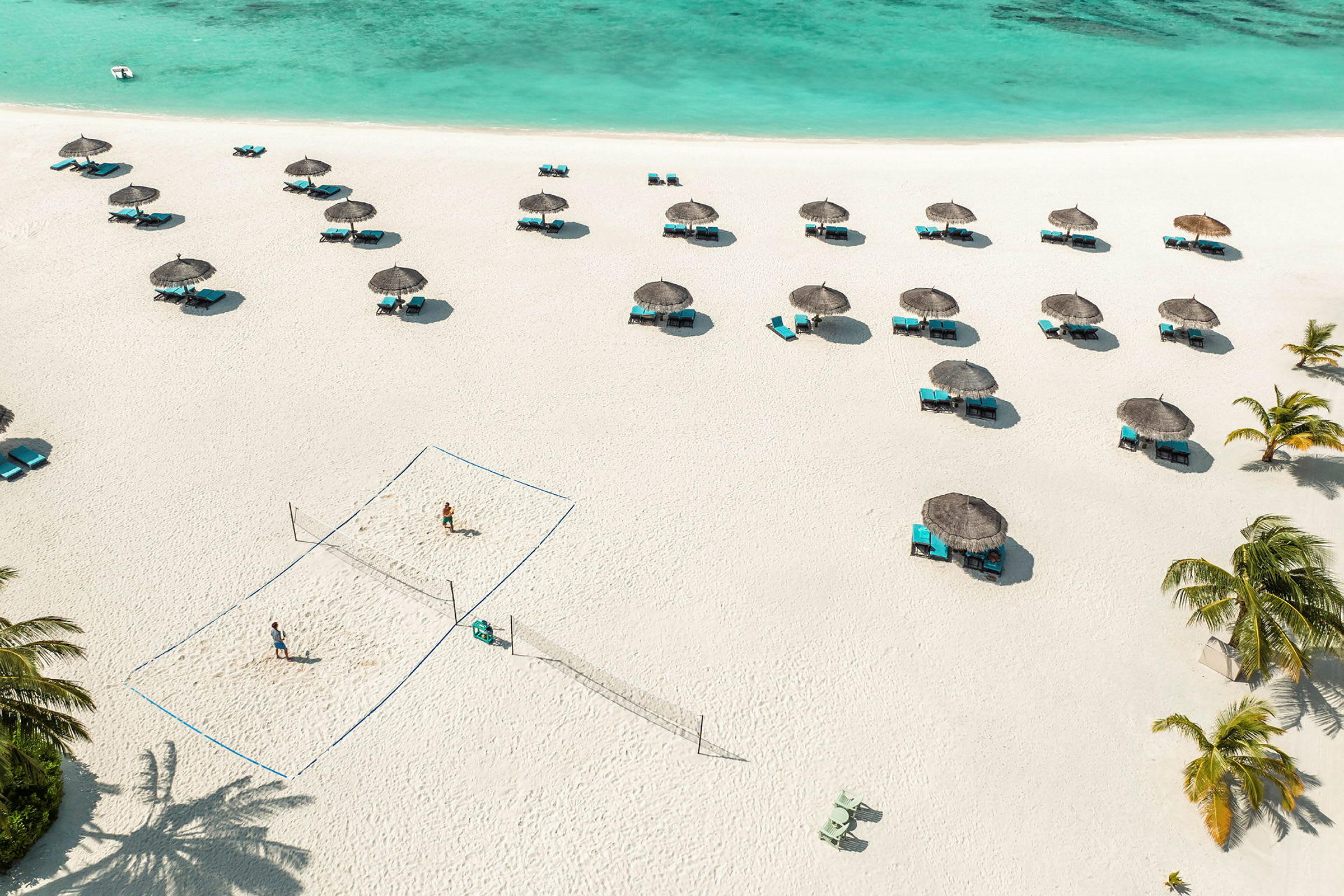 Strand med parasoller, liggestole og et volleyballnet. (AI-genereret tekst)