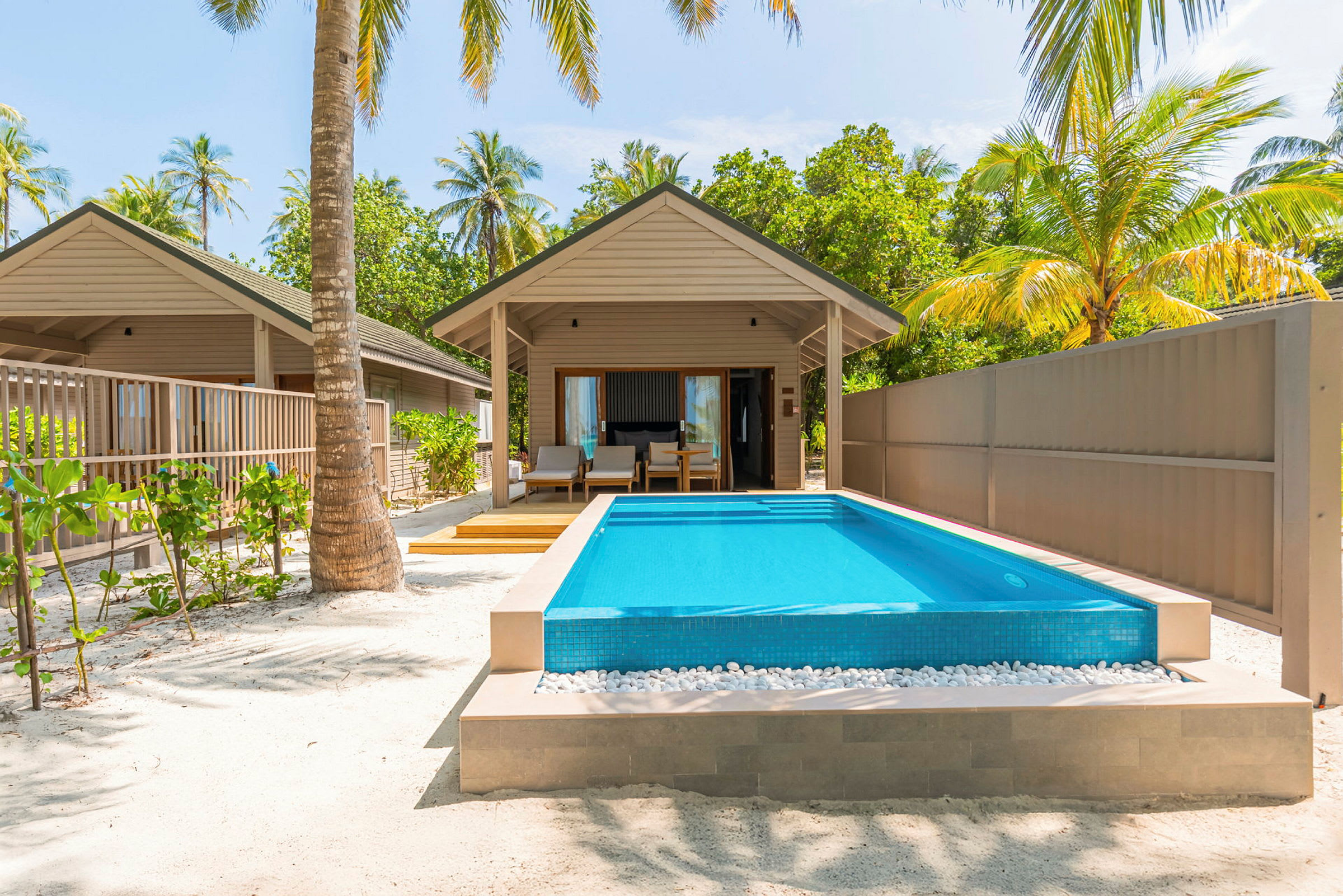 En bungalow med privat pool og omkringliggende palmer. (AI-genereret tekst)