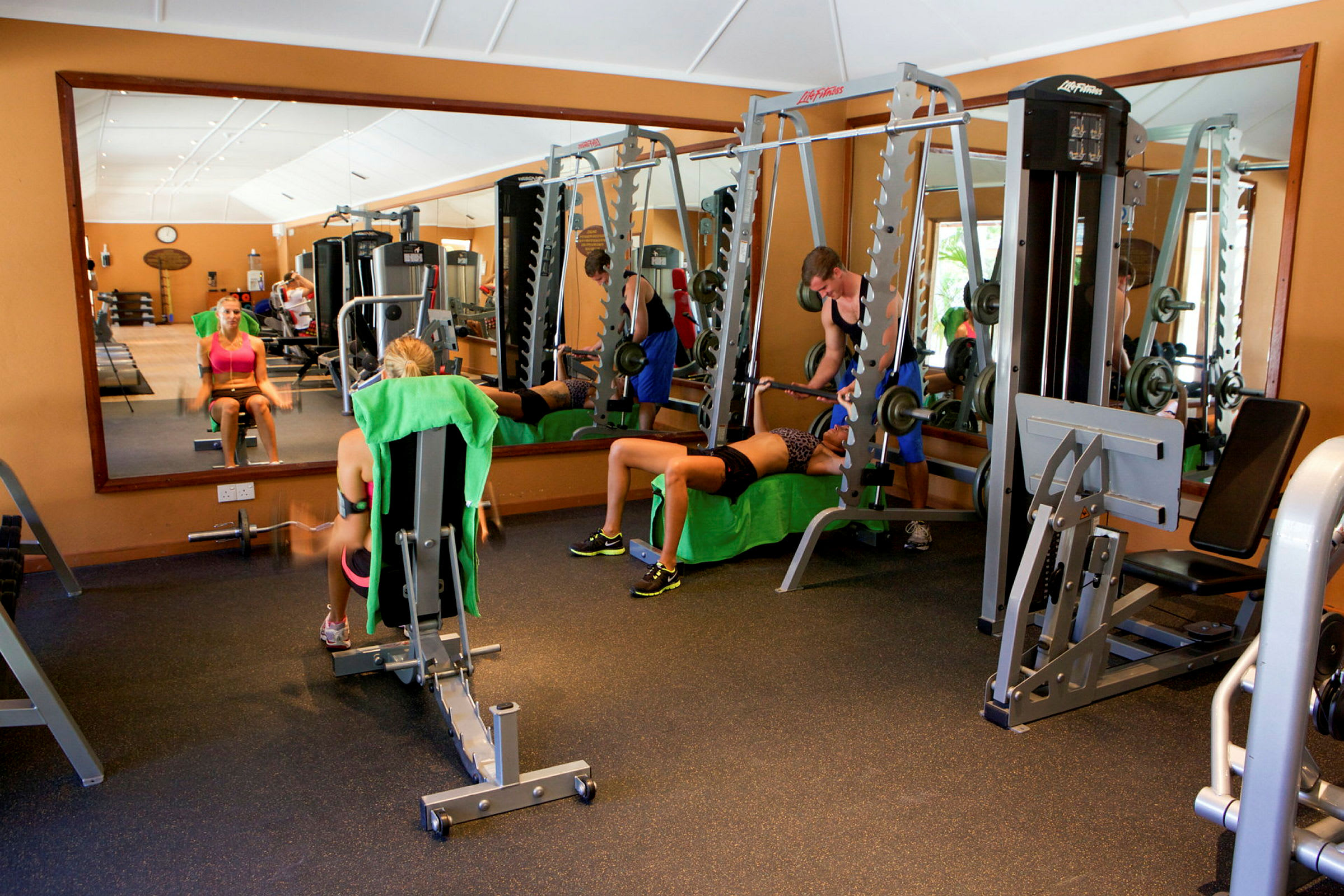 Et fitnesscenter med personer, der træner med forskellige træningsredskaber. (AI-genereret tekst)
