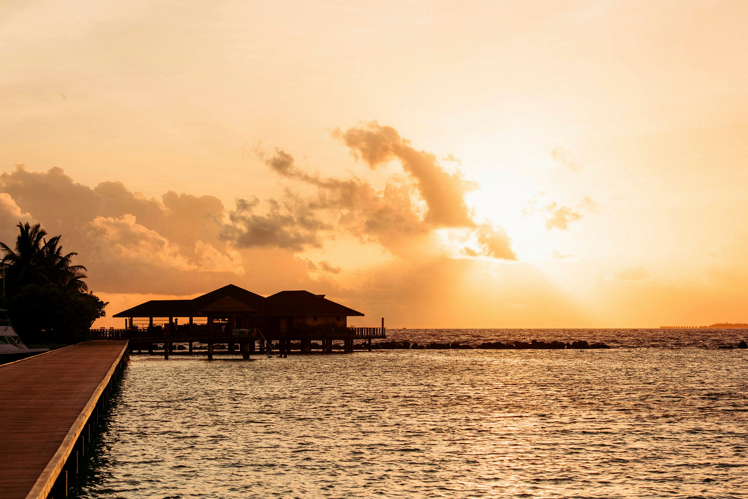 Solnedgang over en overwater-villa ved havet. (AI-genereret tekst)