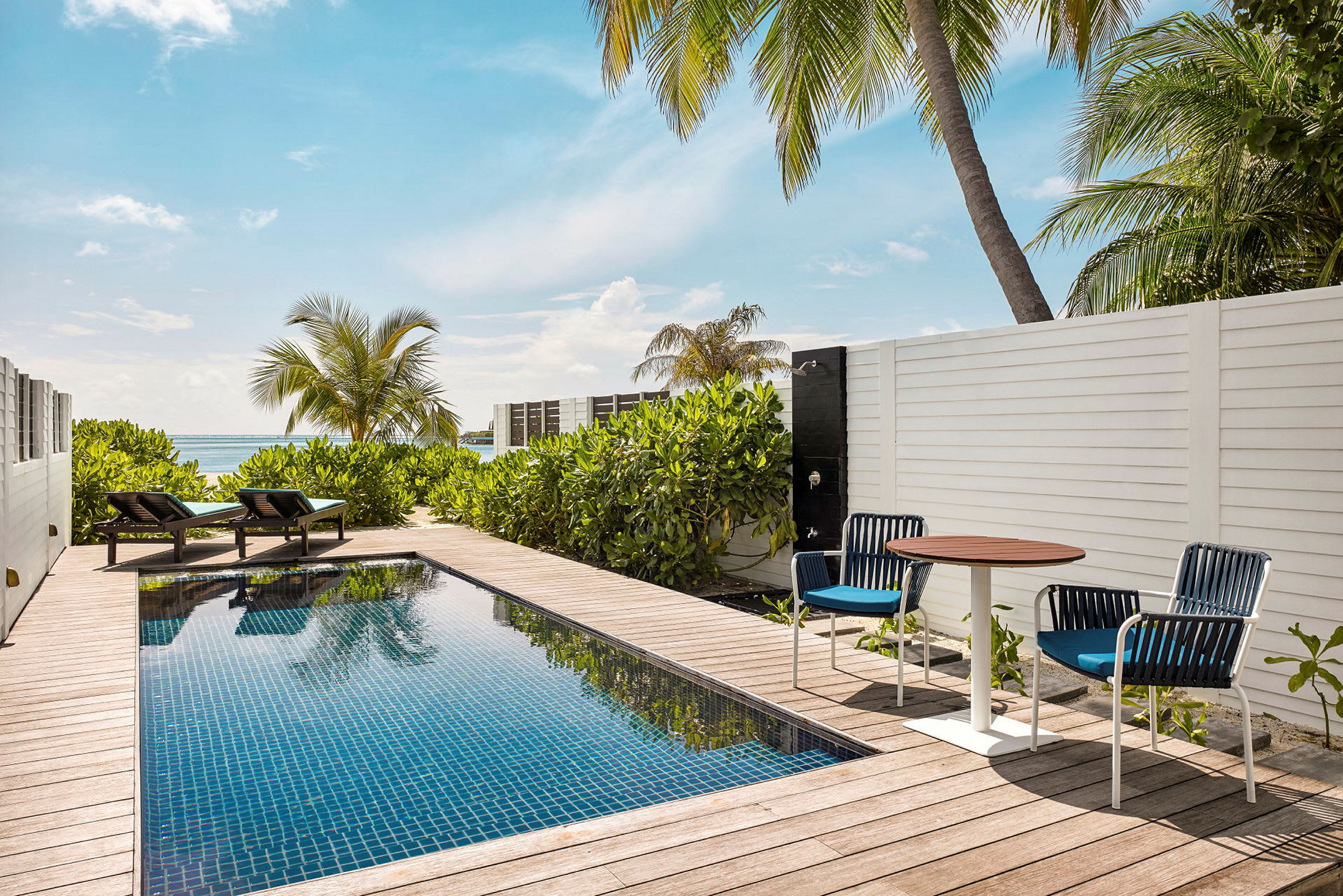 Privat pool på en terrasse med solsenge og havudsigt. (AI-genereret tekst)
