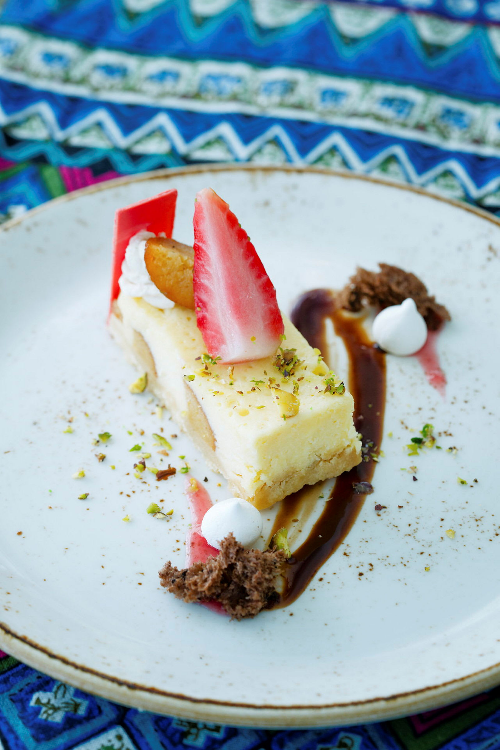En dessert med cheesecake, jordbær og dekorationer på en tallerken. (AI-genereret tekst)