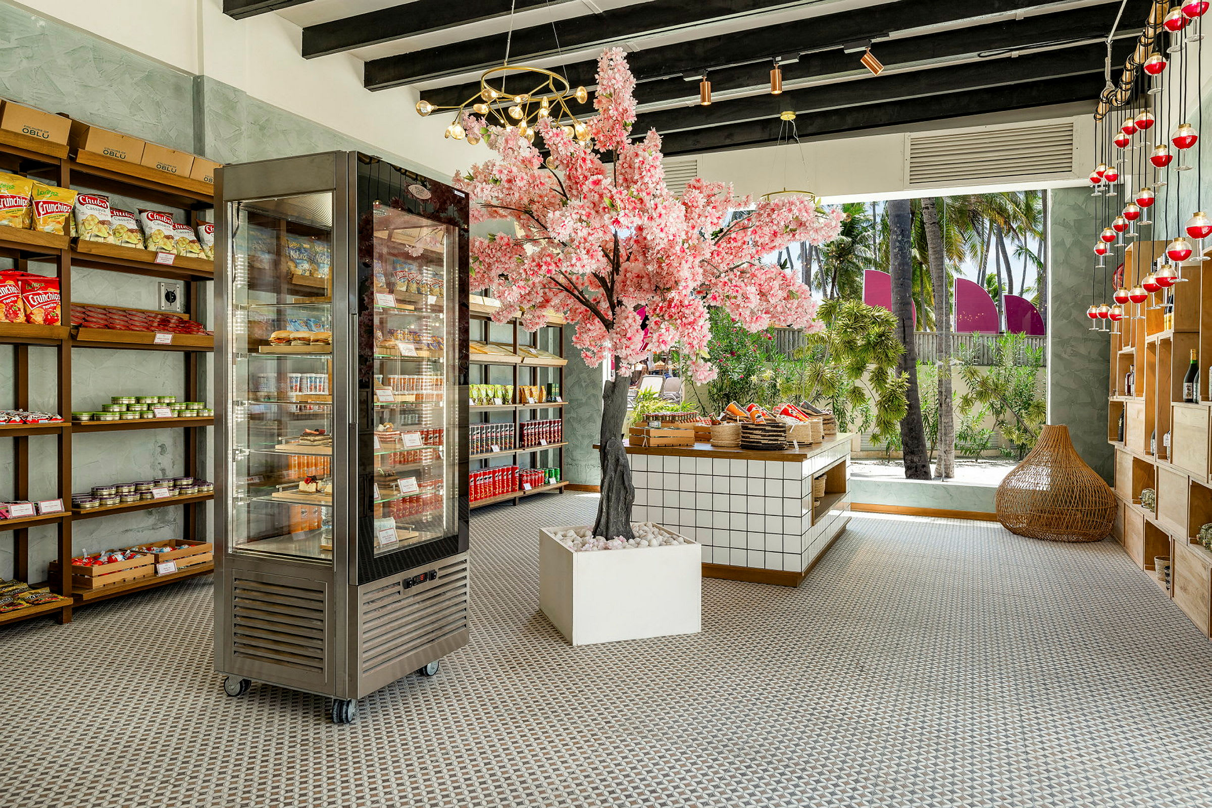 En indendørsbutik med en lyserød blomstertrædekoration, hylder fyldt med varer og et køleskab. (AI-genereret tekst)