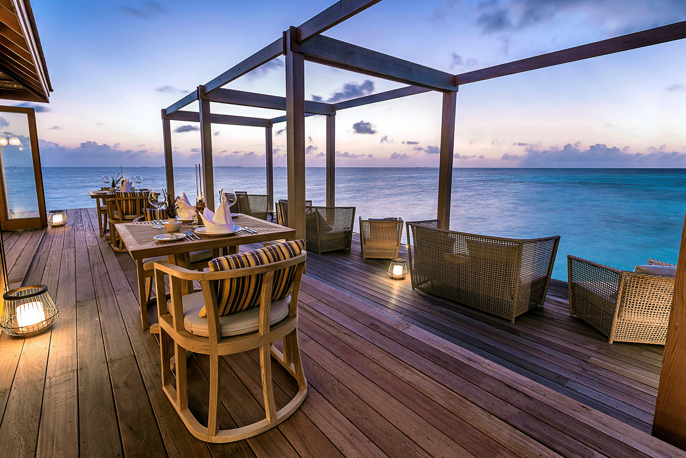 Eksklusiv restaurant ved havet med siddepladser og opdækning på en terrasse. (AI-genereret tekst)